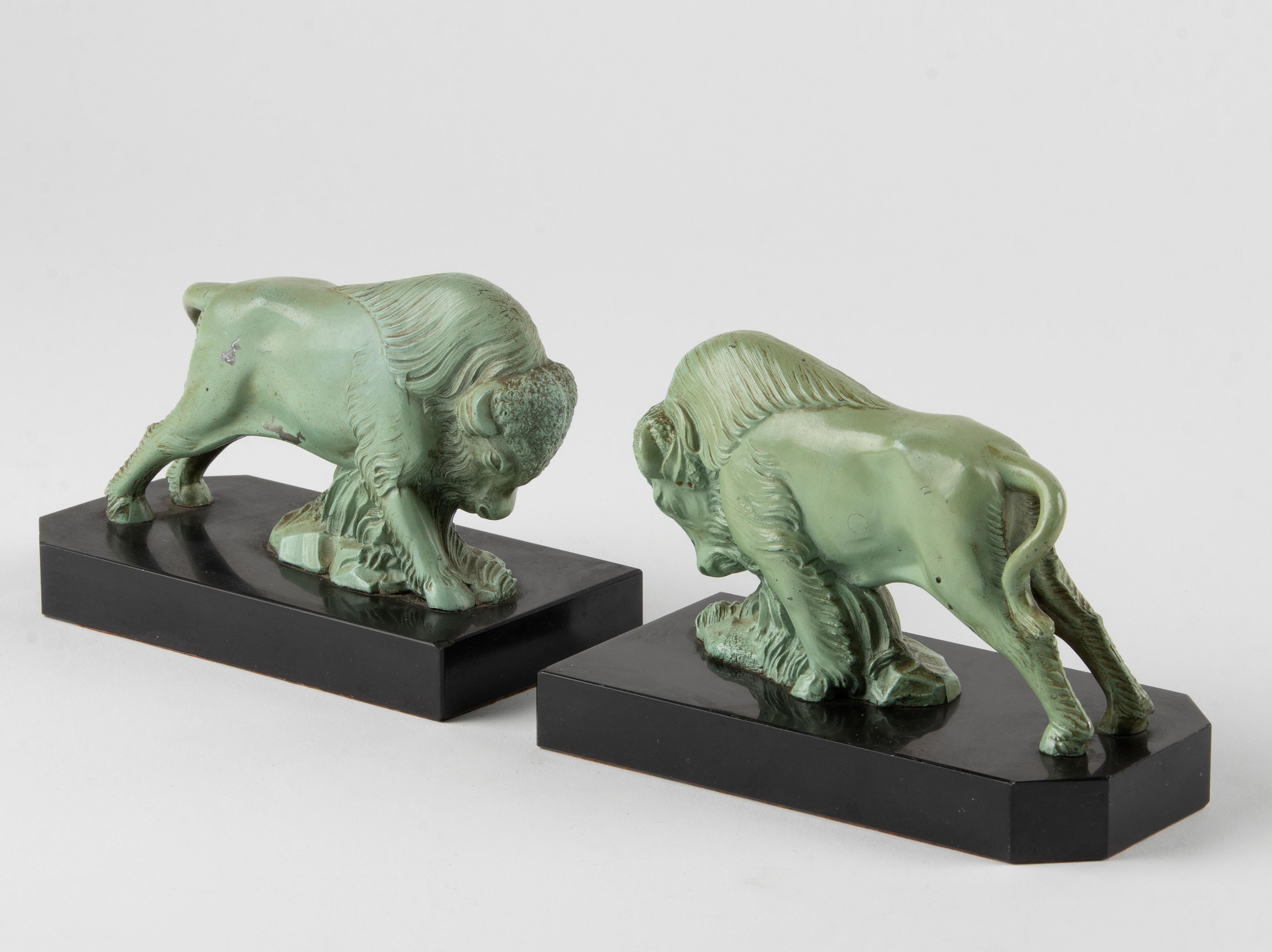 Nice pair of Art Deco period book ends with sculptures of bison. Made of spelter, patinated in a green bronze-like color, on marble bases. Not marked. In good condition with minor signs of age.
 