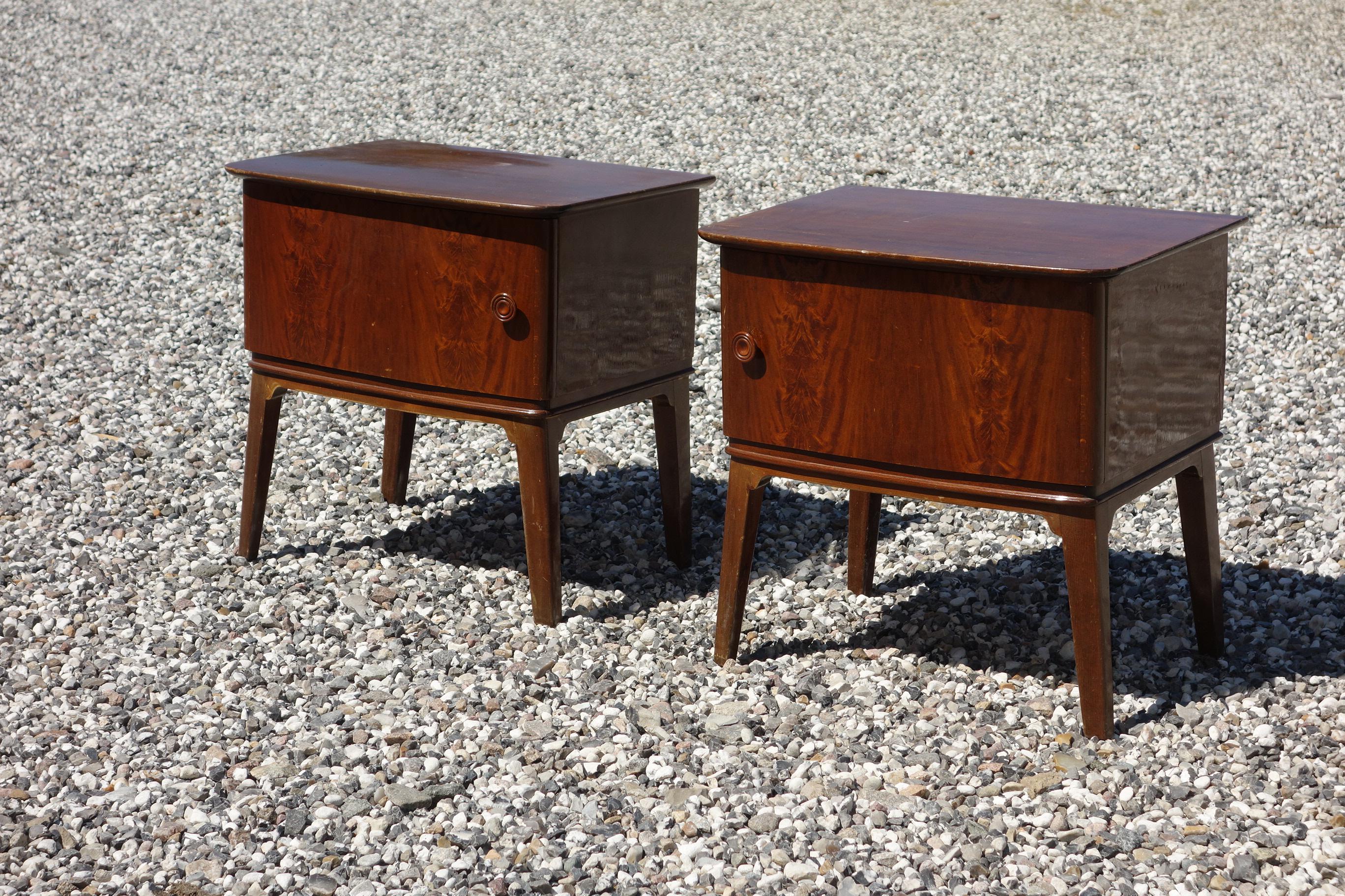 A pair of 1940s-1950s bedside tables in flamed mahogany wood.