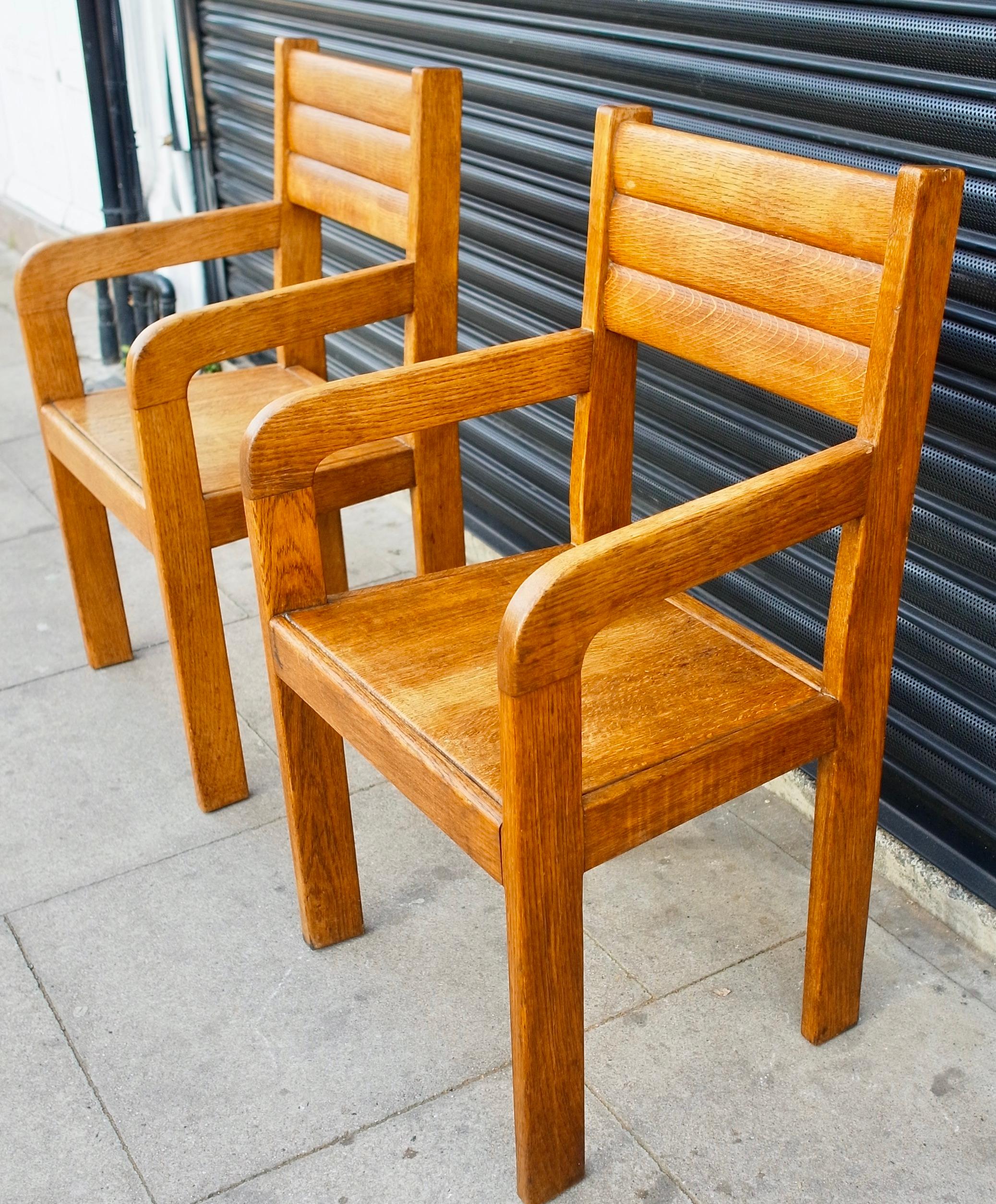 A pair of original and unique English 1949s Oak handmade carver/side chairs. Although, the maker is not known, the chairs show both care and quality in their construction.