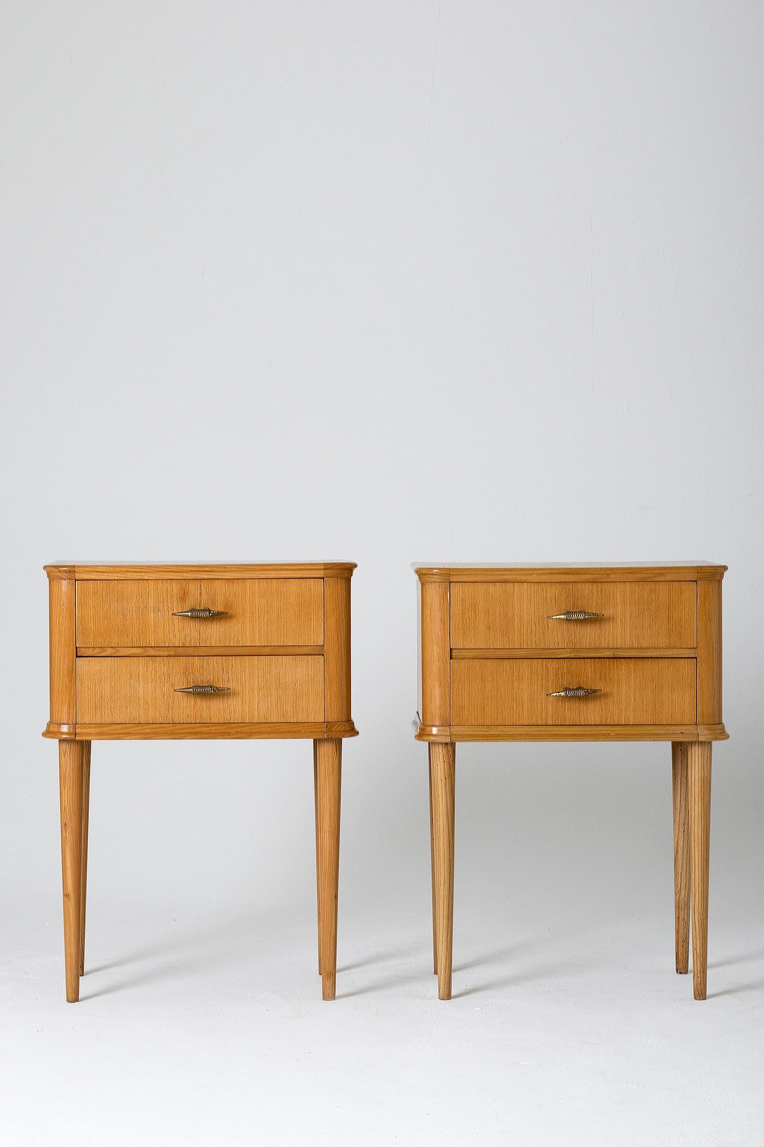 A pair of oak bedside tables, the two drawers with unusual brass handles resting on four tapered legs.
Italy, circa 1940.