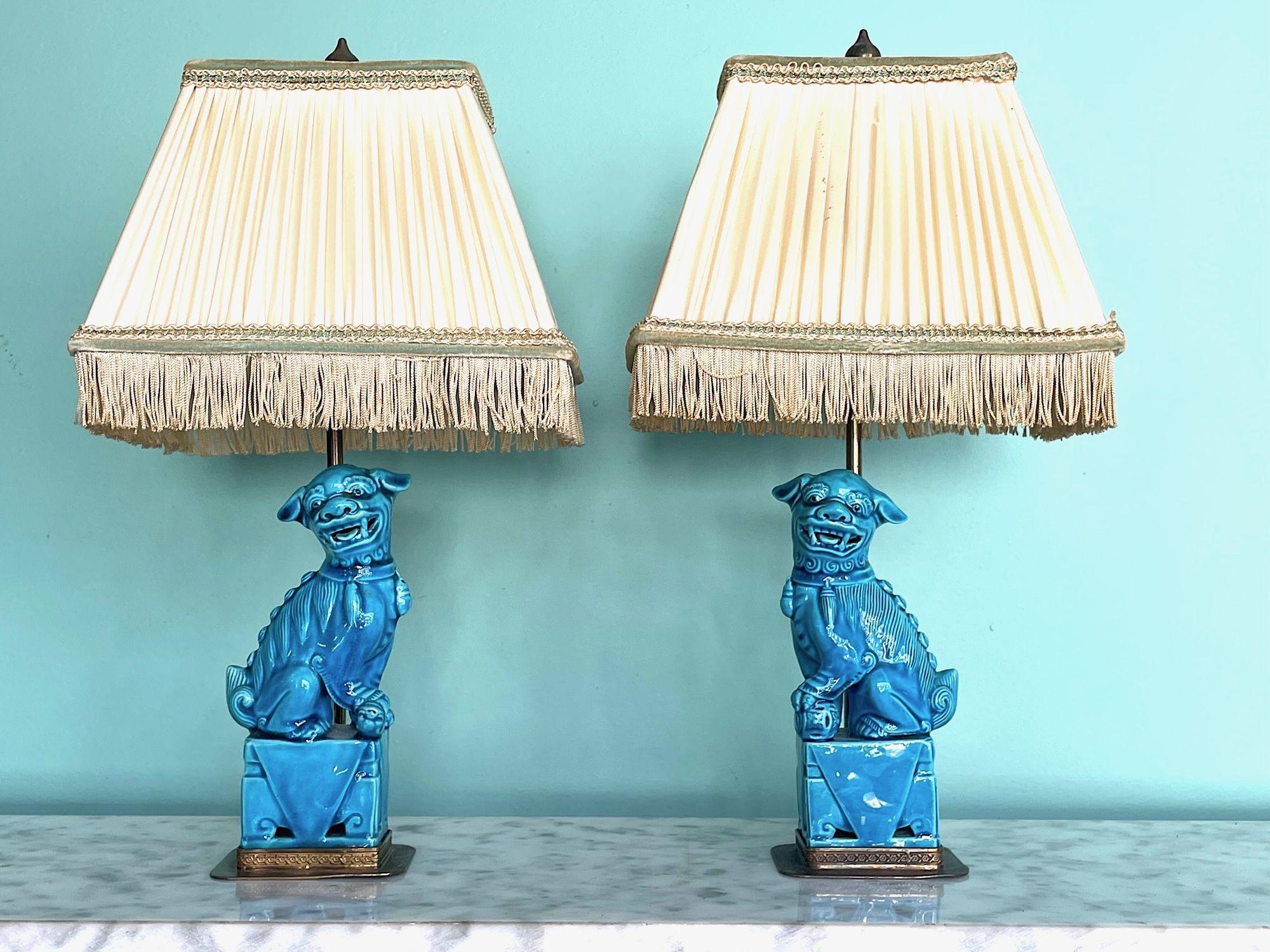 A pair of 1950s turquoise ceramic foo dog lamps on decorative brass base with orignal shades with adjustable brass shade holders and finials. Re wired with new brass fittings, antique gold cord flex and switch.