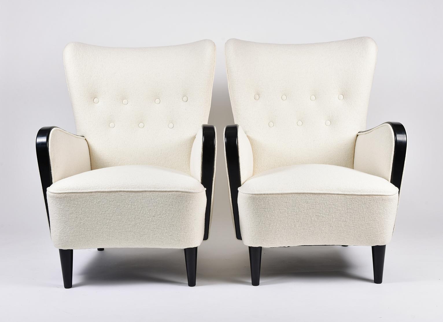 A pair of ebonised beech wood buttoned armchairs
newly upholstered in ivory boiled wool.
France, circa 1950.