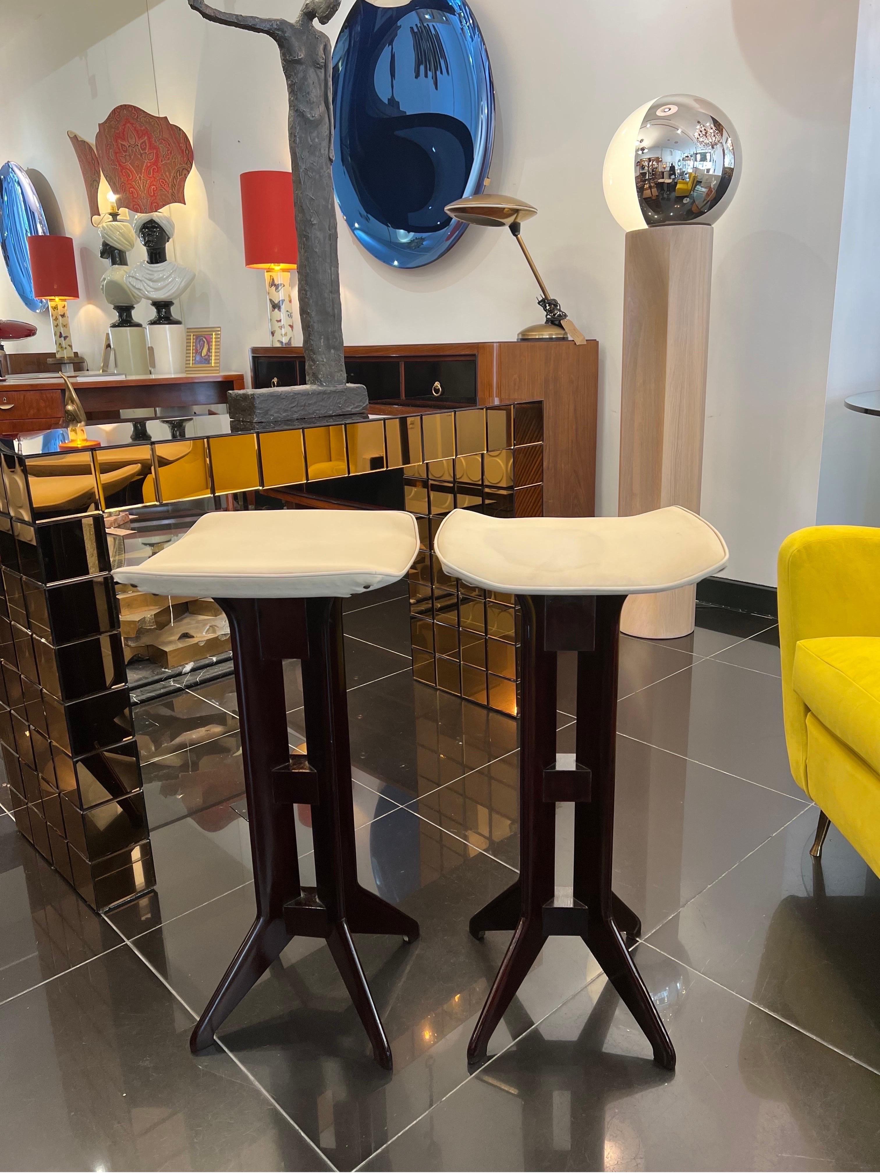 A beautiful pair of 1950s Italian bar stools in a fully restored and dark polished cherry wood with their original cream leatherette upholstery.

Dimensions: D:36cm W:36cm H:71cm