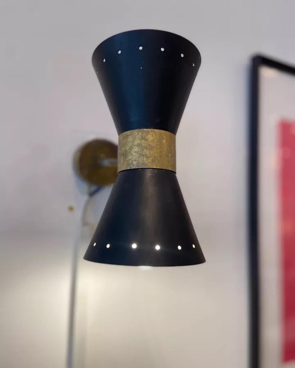 Questa coppia di applique italiane vintage degli anni '50, attribuite a Stilnovo, sono un raffinato esempio di design moderno di metà secolo. Realizzati in acciaio smaltato annerito, sono caratterizzati da eleganti paralumi a forma di cono che