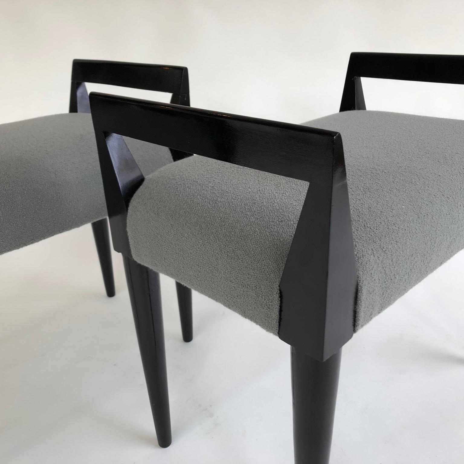 A pair of stools ebonized black and upholstered in grey, Italy, circa 1950s.