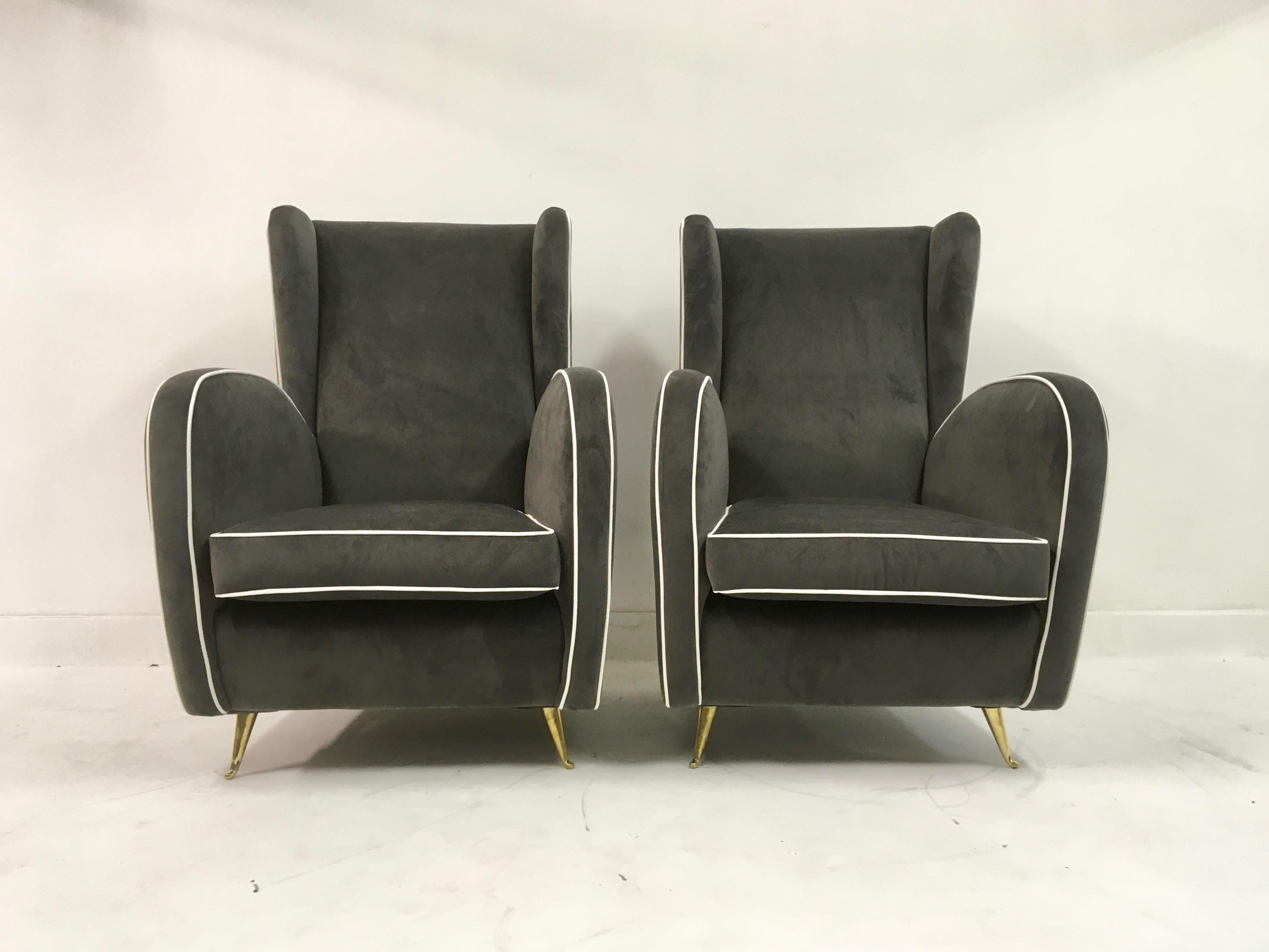 A pair of armchairs

On brass legs

Grey velvet

White piping

High back

Italy, 1950s.