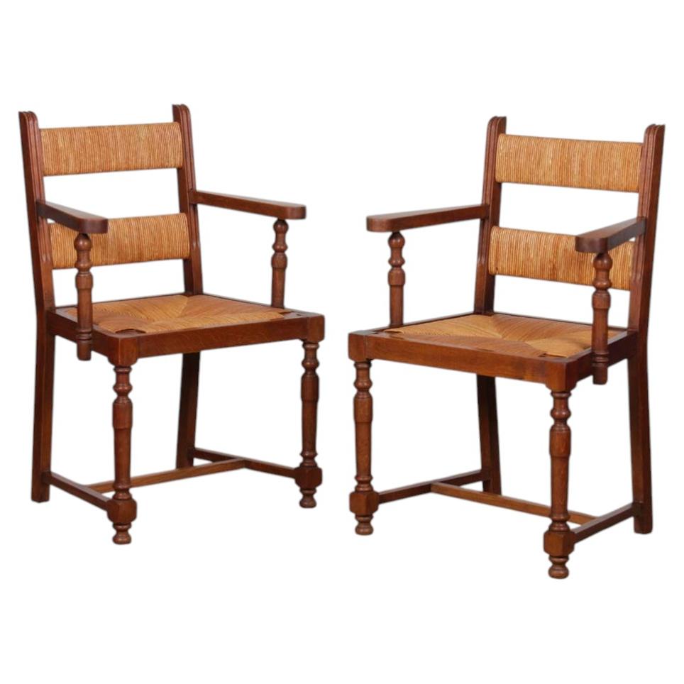 A pair of 1950s oak wicker armchairs