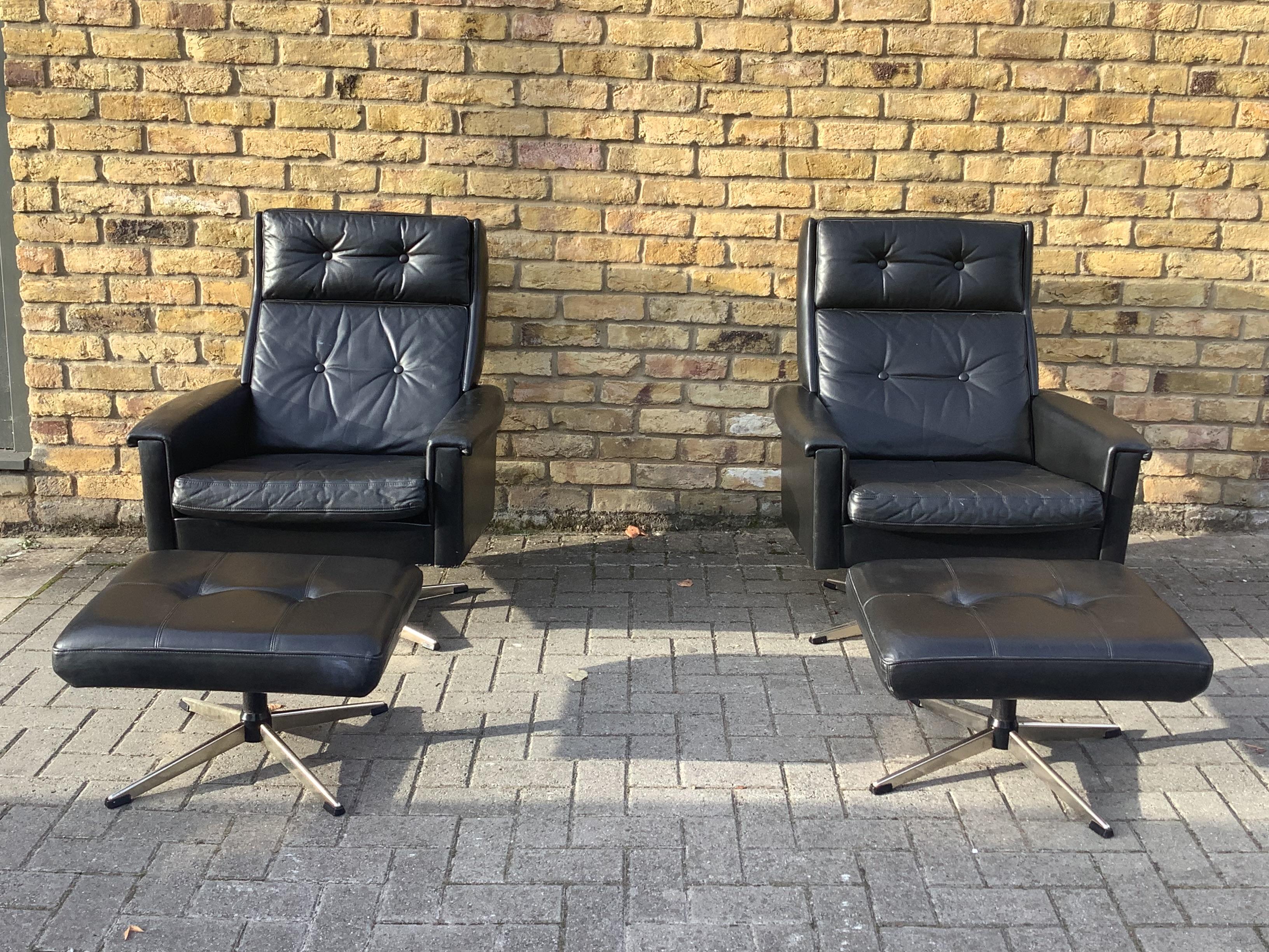 A pair of classic Danish black leather armchairs and matching foot stool 
Both swivel .