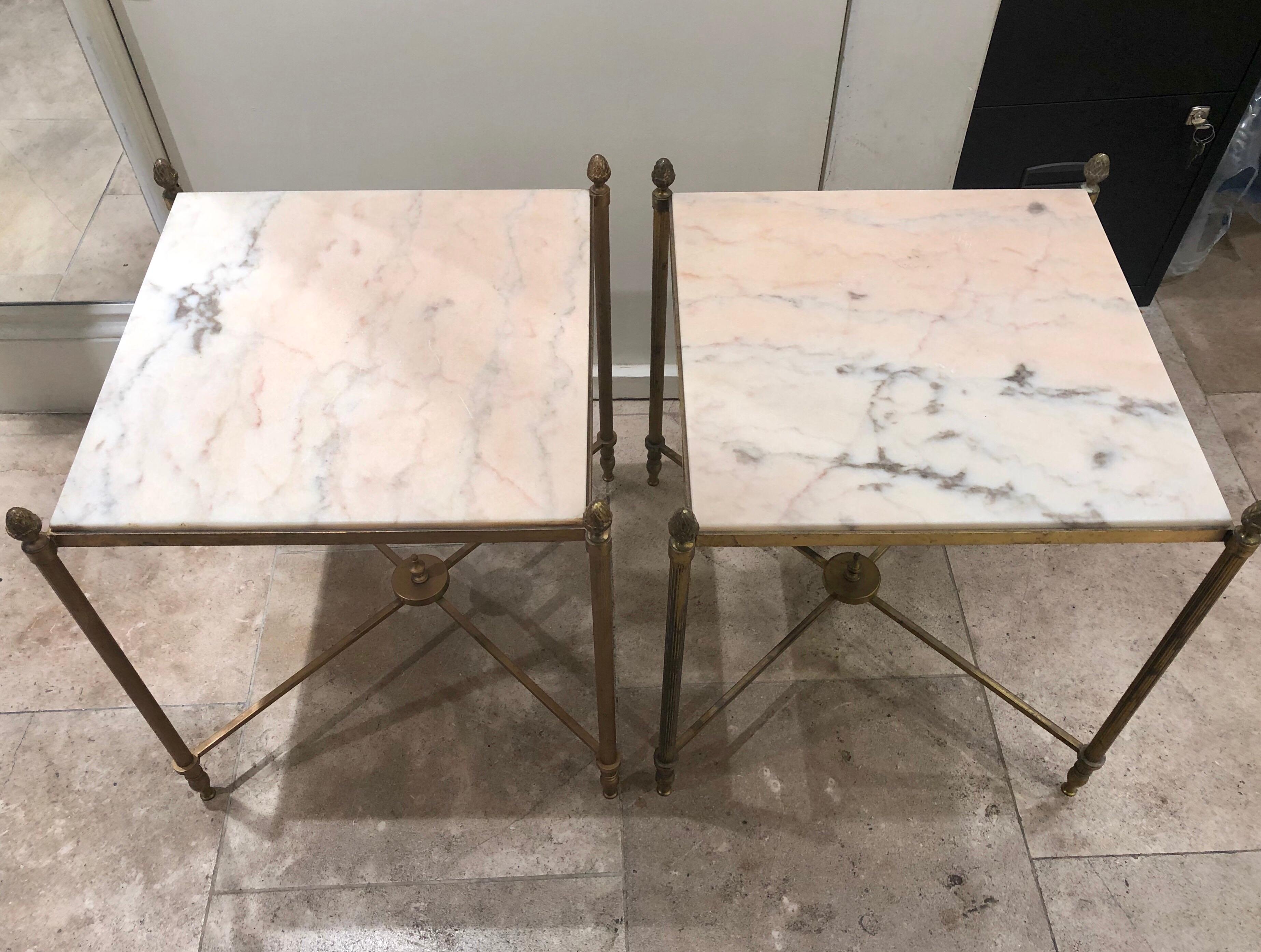 A lovely pair of French brass side tables with delicate fluted legs and artichoke details. The tops are white marble with a slightly pink tone.