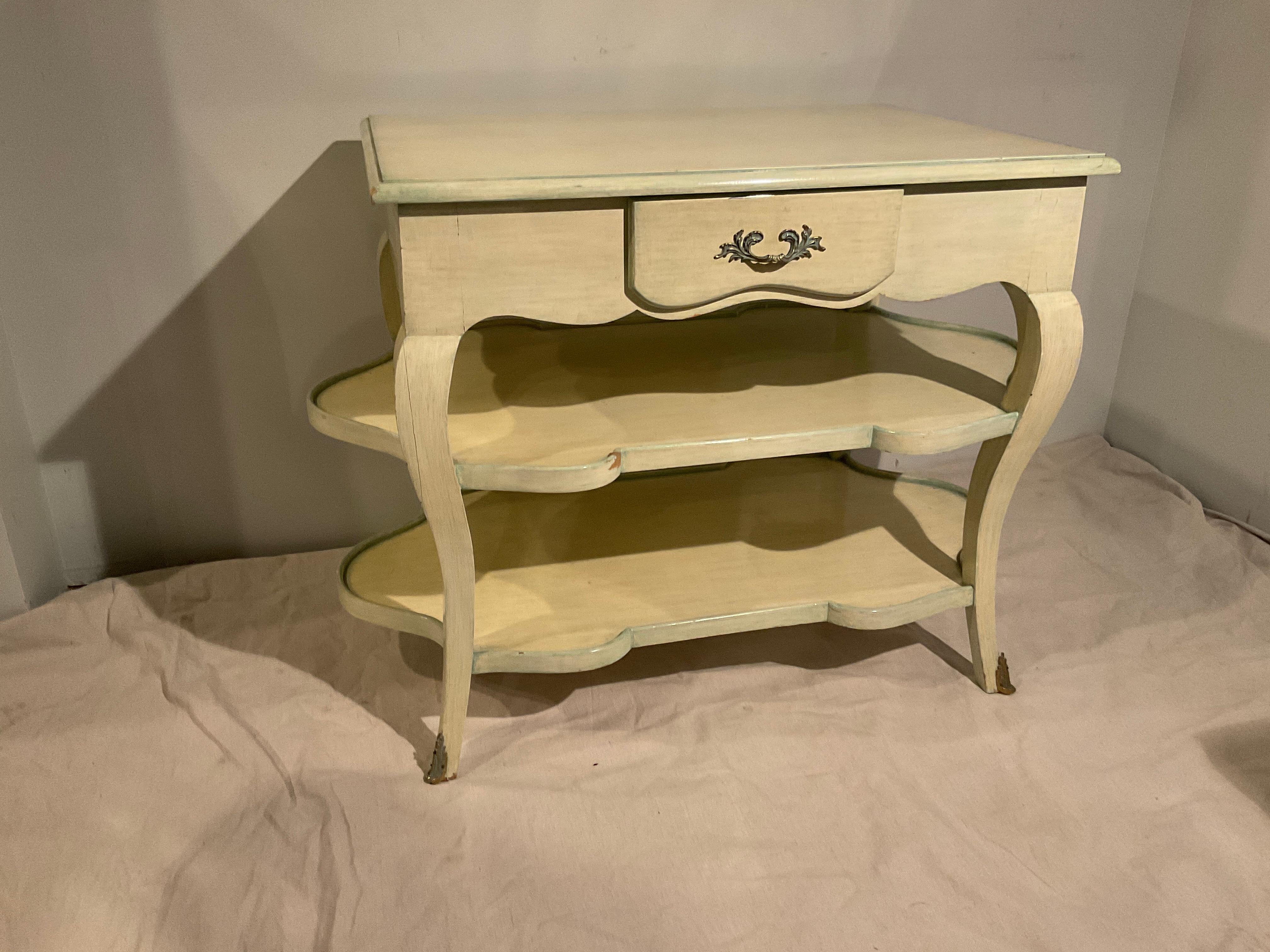 A pair of 1950s three tier end tables . Great for a living room or bedroom. Well made, solid tables . Each table has a shelf that slides out from the side. One table has a splatter of paint on it as shown in image 12.