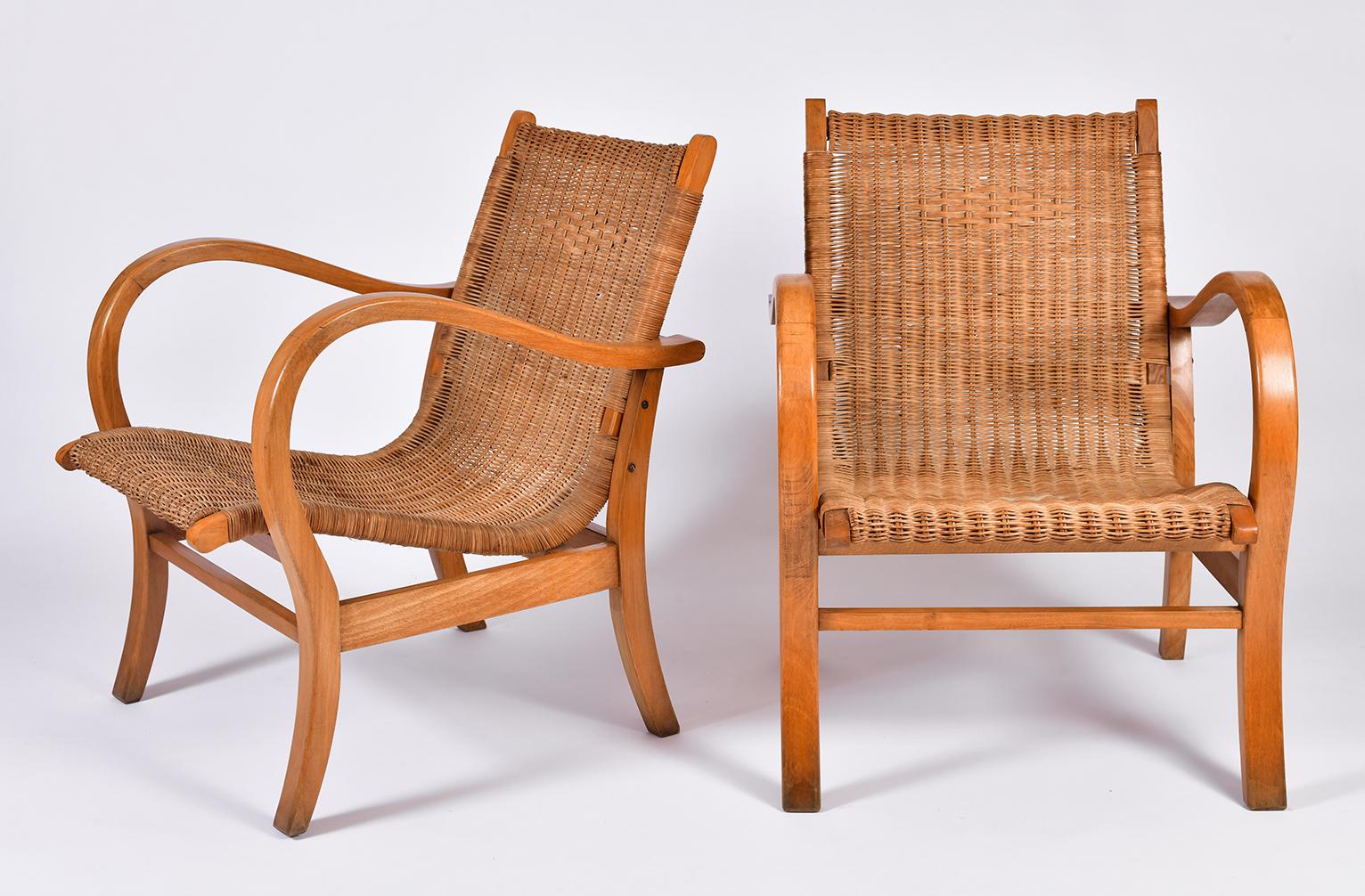 A pair of wicker and beechwood armchairs
France, circa 1950.