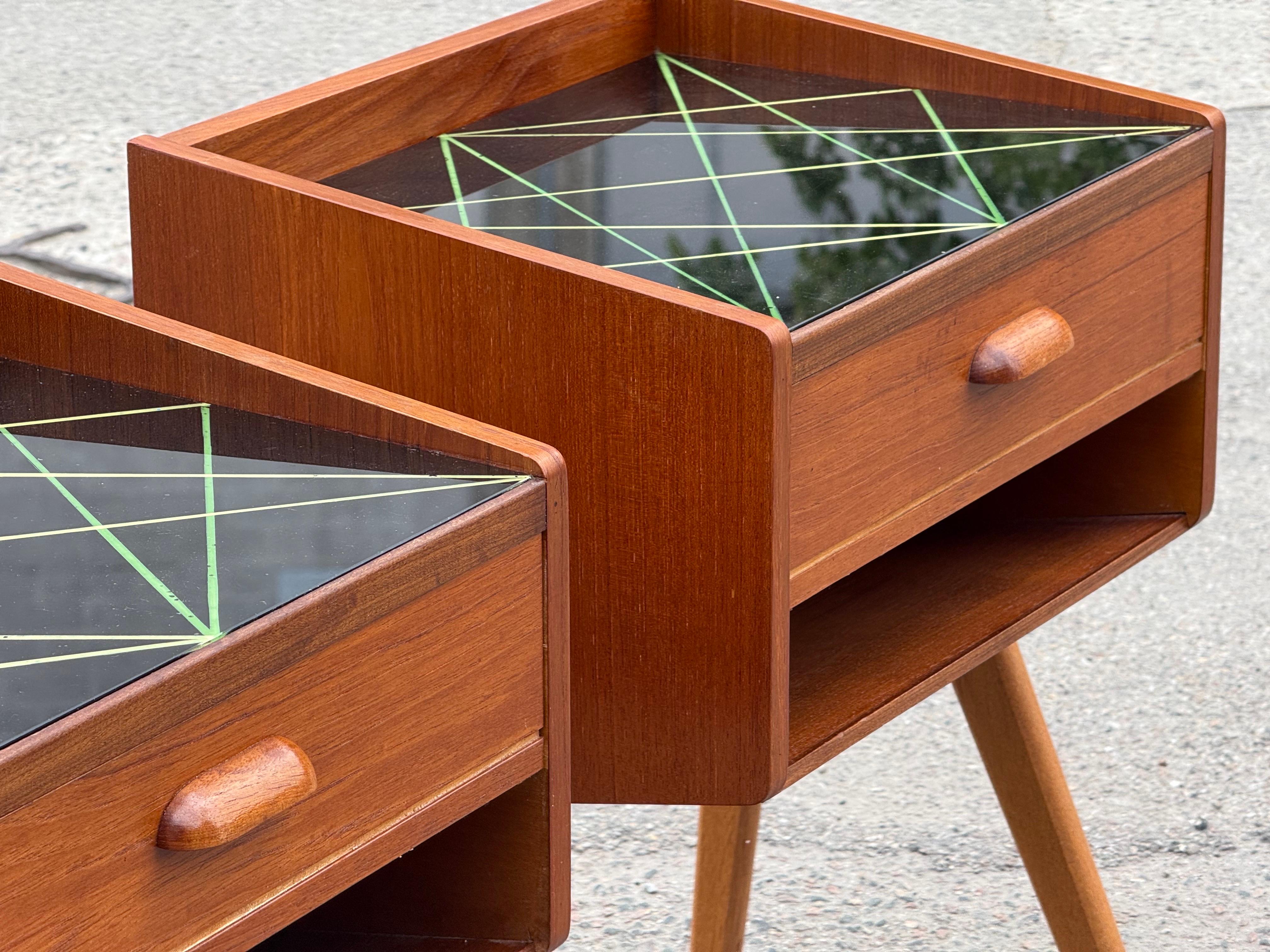 Danois Paire de tables de nuit des années 1960 en teck avec pieds en Oak et plateau en verre décoré en noir en vente