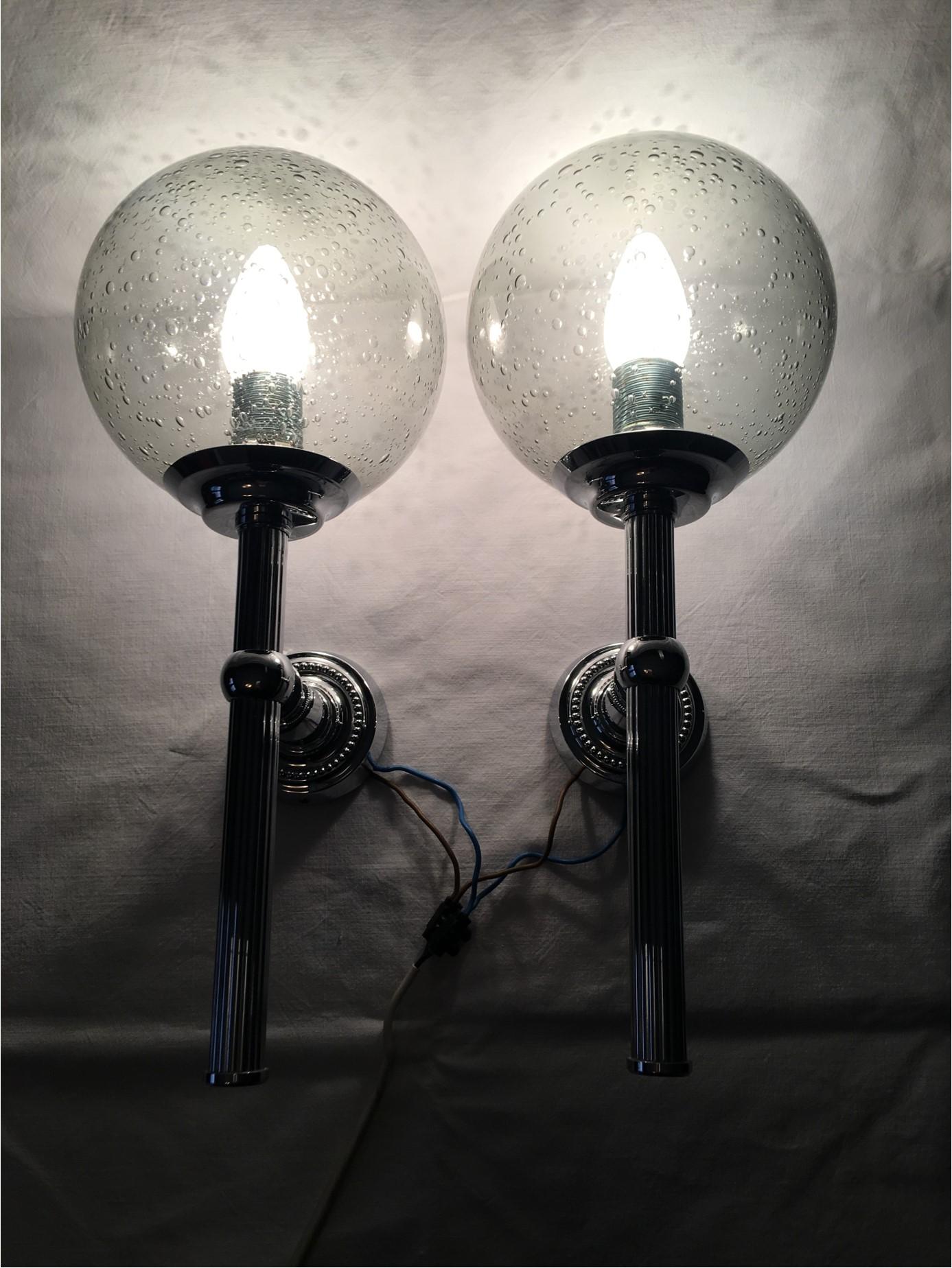 A unique and lovely pair of 1960s chrome and smoked air bubbles glass sconces from Germany. Very Art Deco looking fixtures are crowned with a lovely glass fitting complete with air bubbles that help create a magnificent lighting effect. Very nice