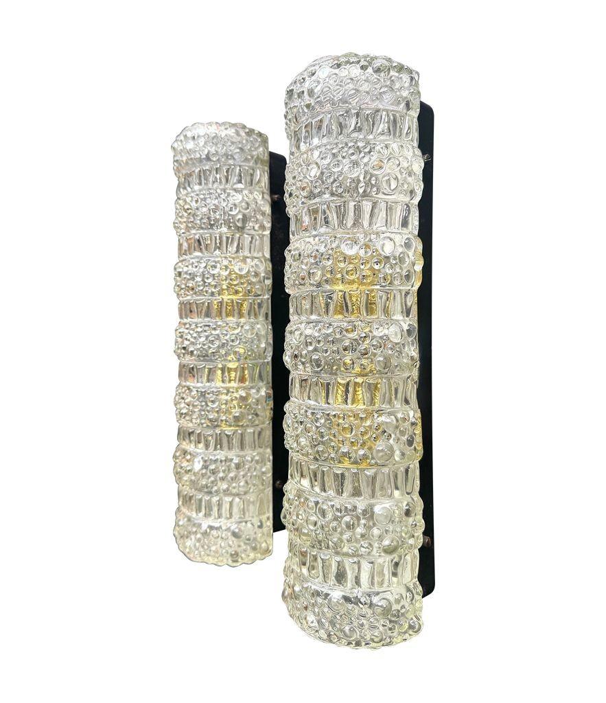 A pair of 1960s  clear moulded textured geometric glass wall lights on black metal wall brackets. Each rewired with tow new brass fittings and PAT tested. 