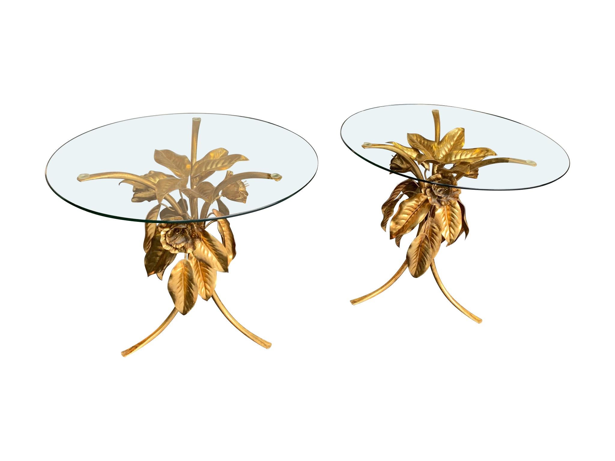 A pair of 1960s gilt metal side tables with flowers and leaf bases with circular glass tops.