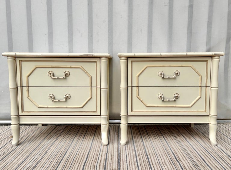 A Pair of Vintage Mid-Century Modern Hollywood Regency Faux Bamboo night stands by Broyhill . Circa 1960s
Feature a Chinoiserie inspired design with an off-white finished, white laminated tops, two drawers each, and brass hardware painted in