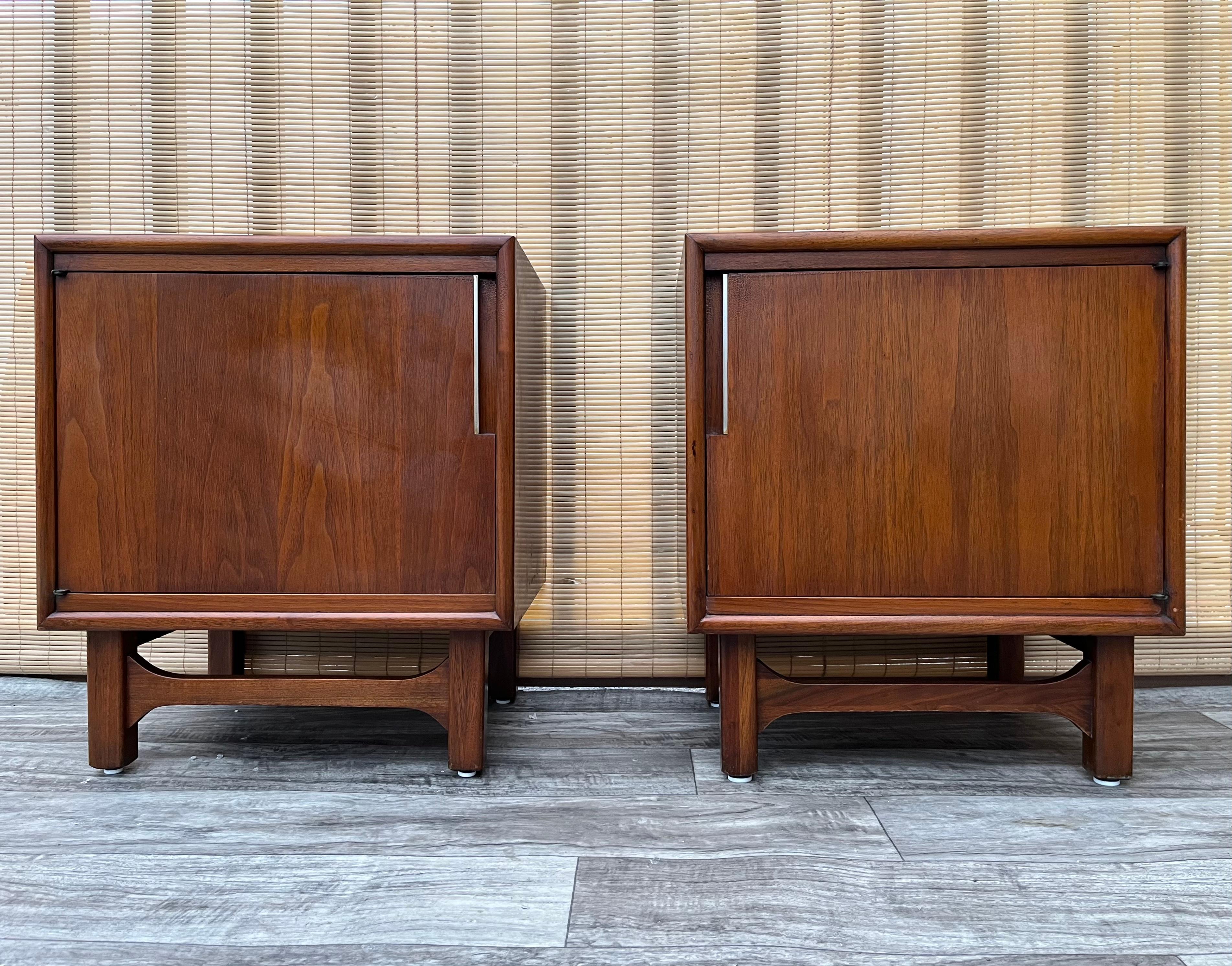 A pair of 1960s Mid-Century Modern Nightstands by Cavalier Furniture. Dated 1967.
Features a quintessential sleek Mid-Century Modern Design with a beautiful dark walnut wood grain, brass hardware and plenty of storage space, with a pullout surface