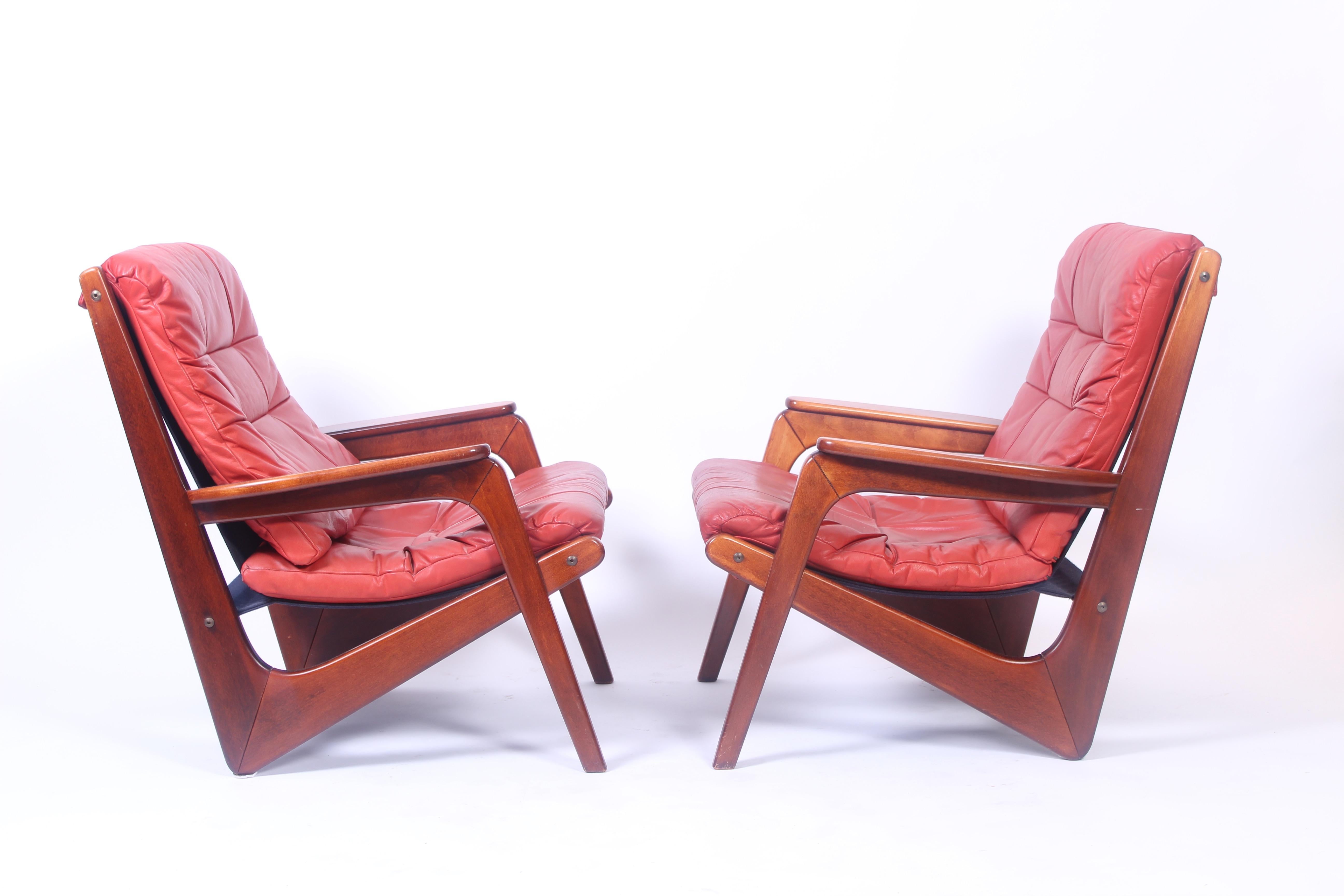 Pair of midcentury Norwegian easy chairs by, for us, unknown designer. Stained solid beech frame and red original leather in excellent vintage condition. 

Excellent vintage condition with very few signs of usage.