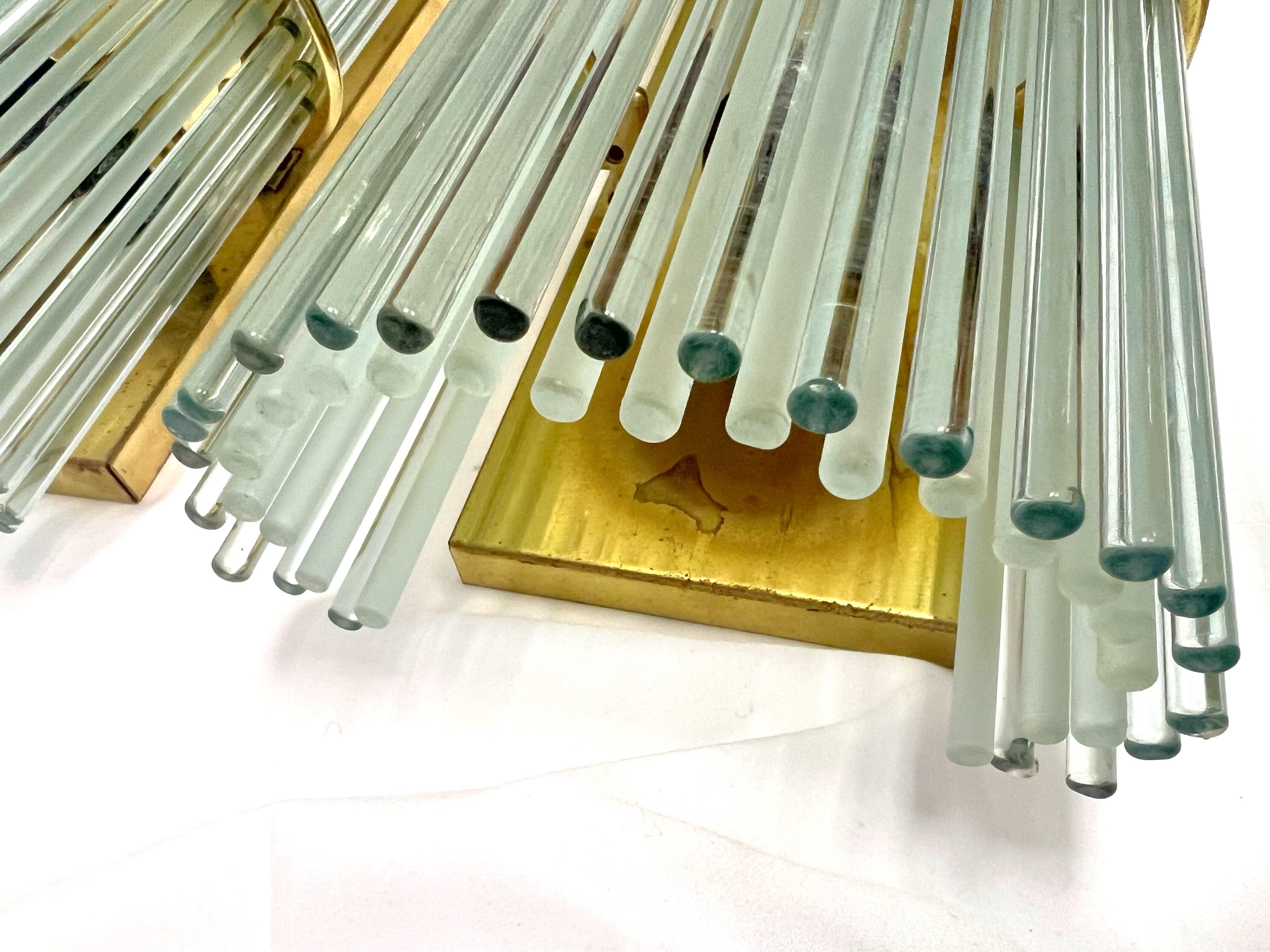A very unique design utilizing thin glass rods as shades. An inner row of frosted rods helps obscure the bulbs, while the outer row of glossy rods add the sparkle. The fixtures have some patina on the brass, and still display very well. There are