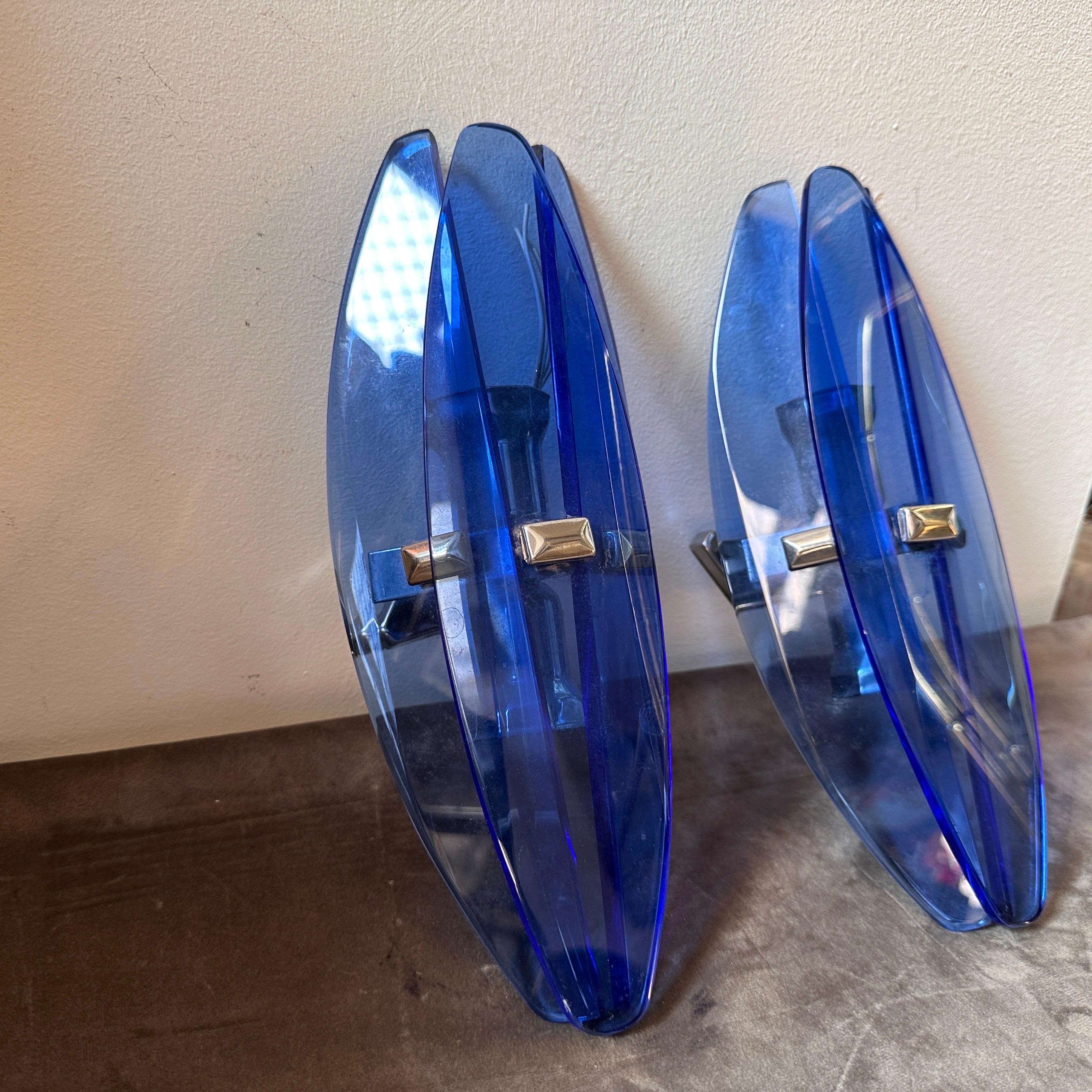 A set of two heavy blu glass wall sconces designed and manufactured in Italy in the Space Age Era by Veca, they are in working order, need two regular e14 bulbs each one. These Wall Sconces by Veca embody the futuristic and avant-garde design