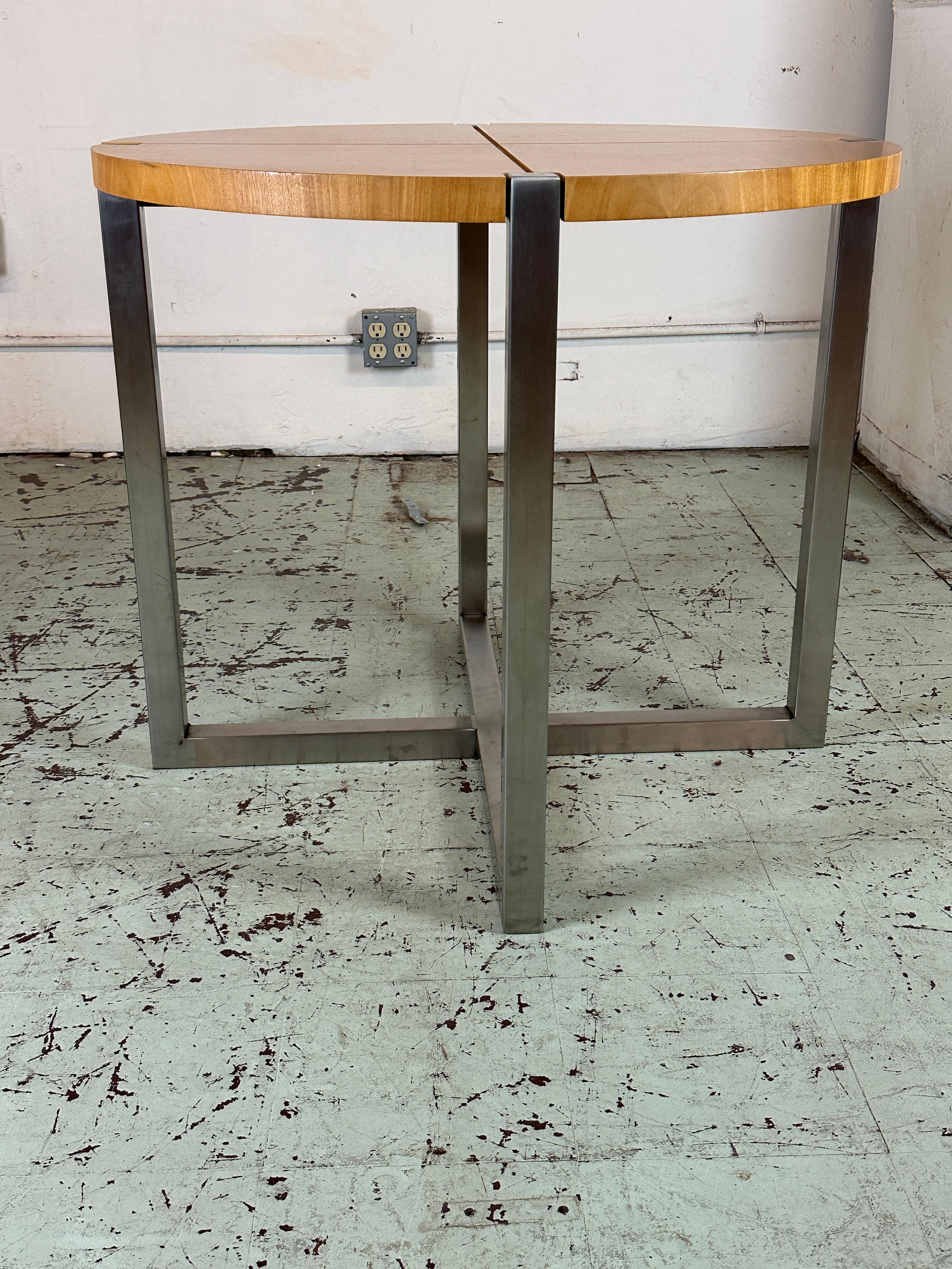 These gueridons or end tables feature a sycamore top split in 4 quarters by a chrome insert matching the base bottom. The legs are made of chromed steel.