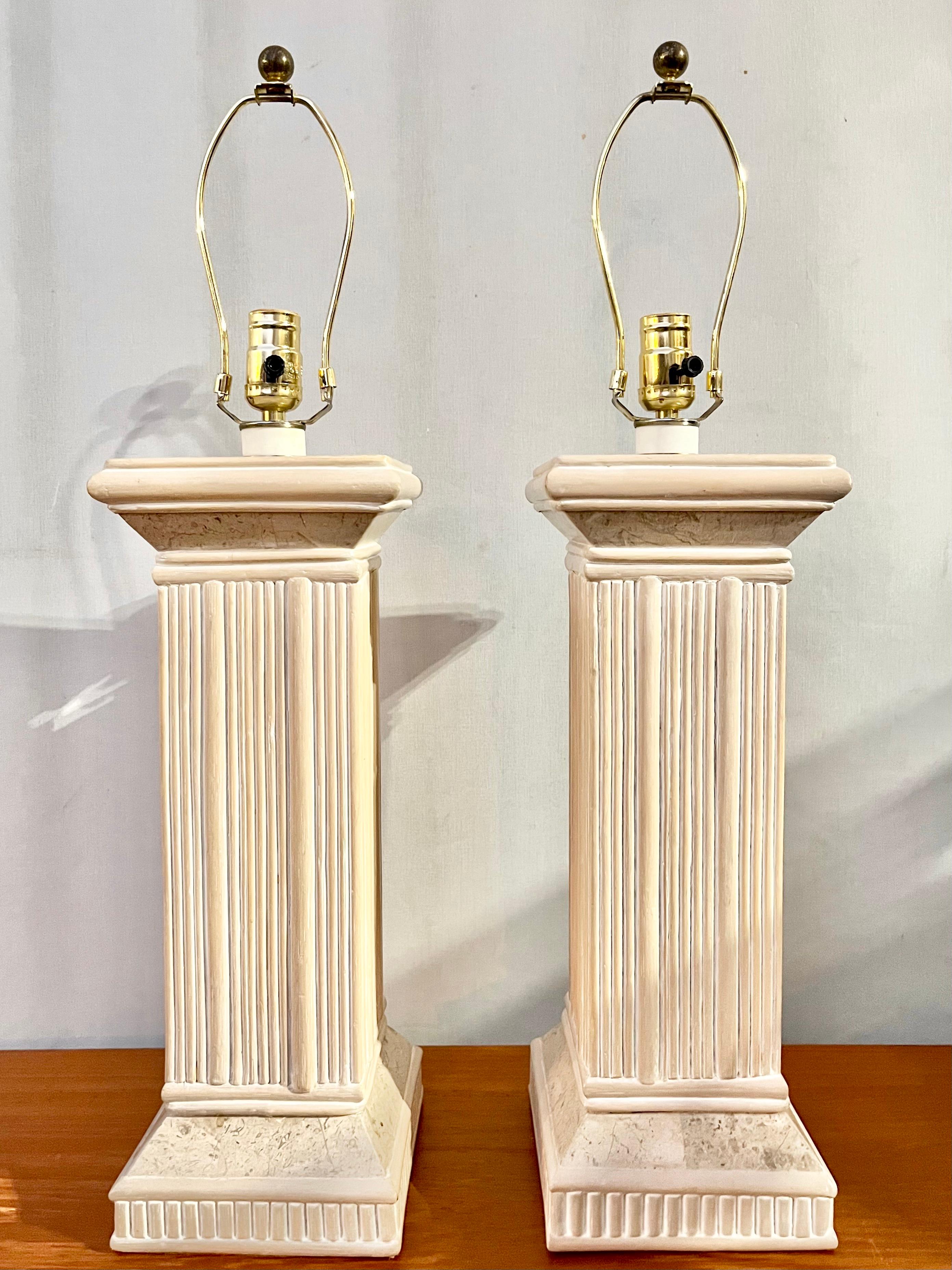 A pair of Hollywood Regency / Coastal Style Pencil Split Reed Rattan and Faux Stone Table Lamps. Circa late 1980s
The lamps feature a soft cream color split rattan body with faux stone trims. 
The table lamps are in very good original cosmetic and