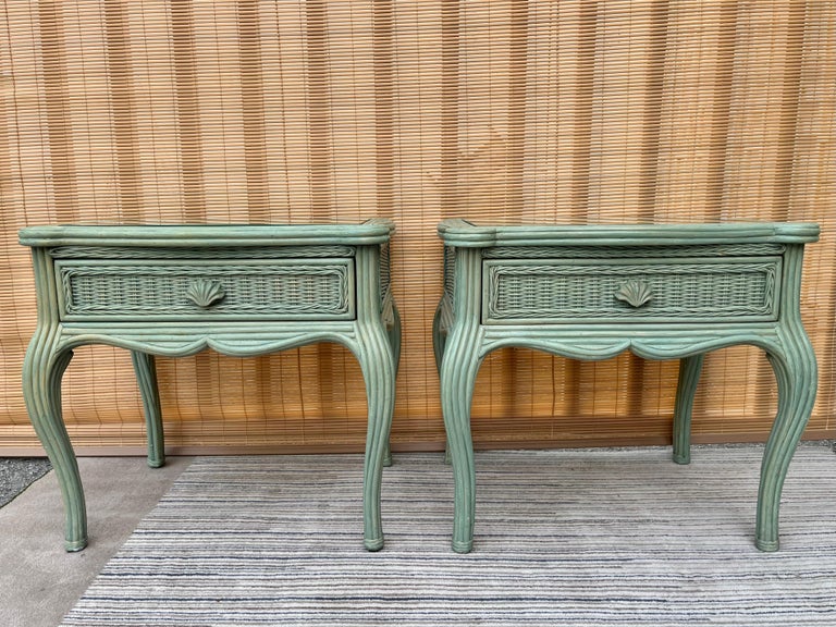 A pair of vintage Coastal Style / Hollywood Regency / Palm Beach Regency Wicker and Split Pencil Reed Night stands or side tables manufactured by Whitecraft Furniture. Circa 1980s .
Feature rounded bent edges, a drawer with beautiful molded