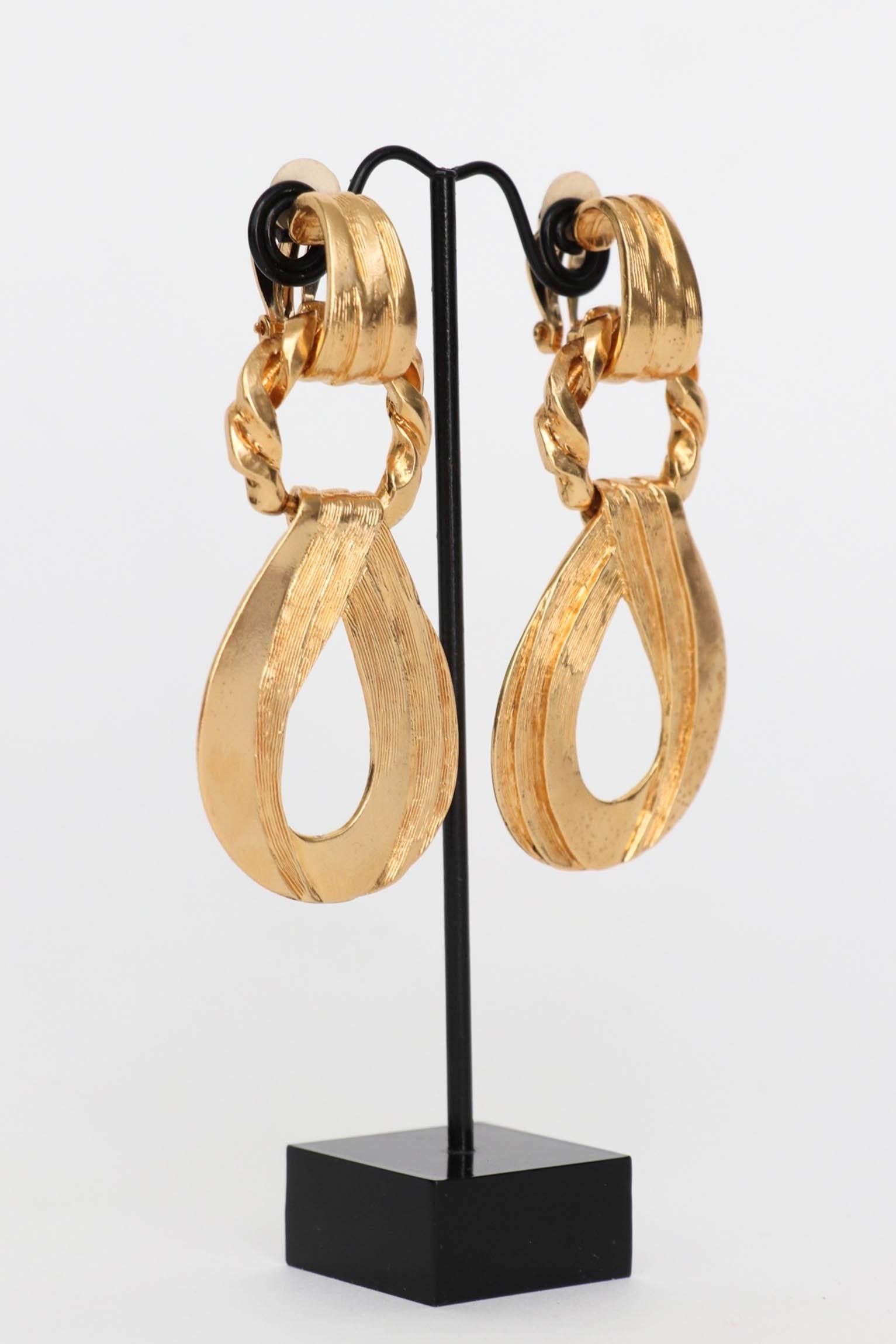 An incredible pair of 1980s Yves Saint Laurent gold toned clip-on earrings with a detachable pendant. 

The earrings are stamped: YSL