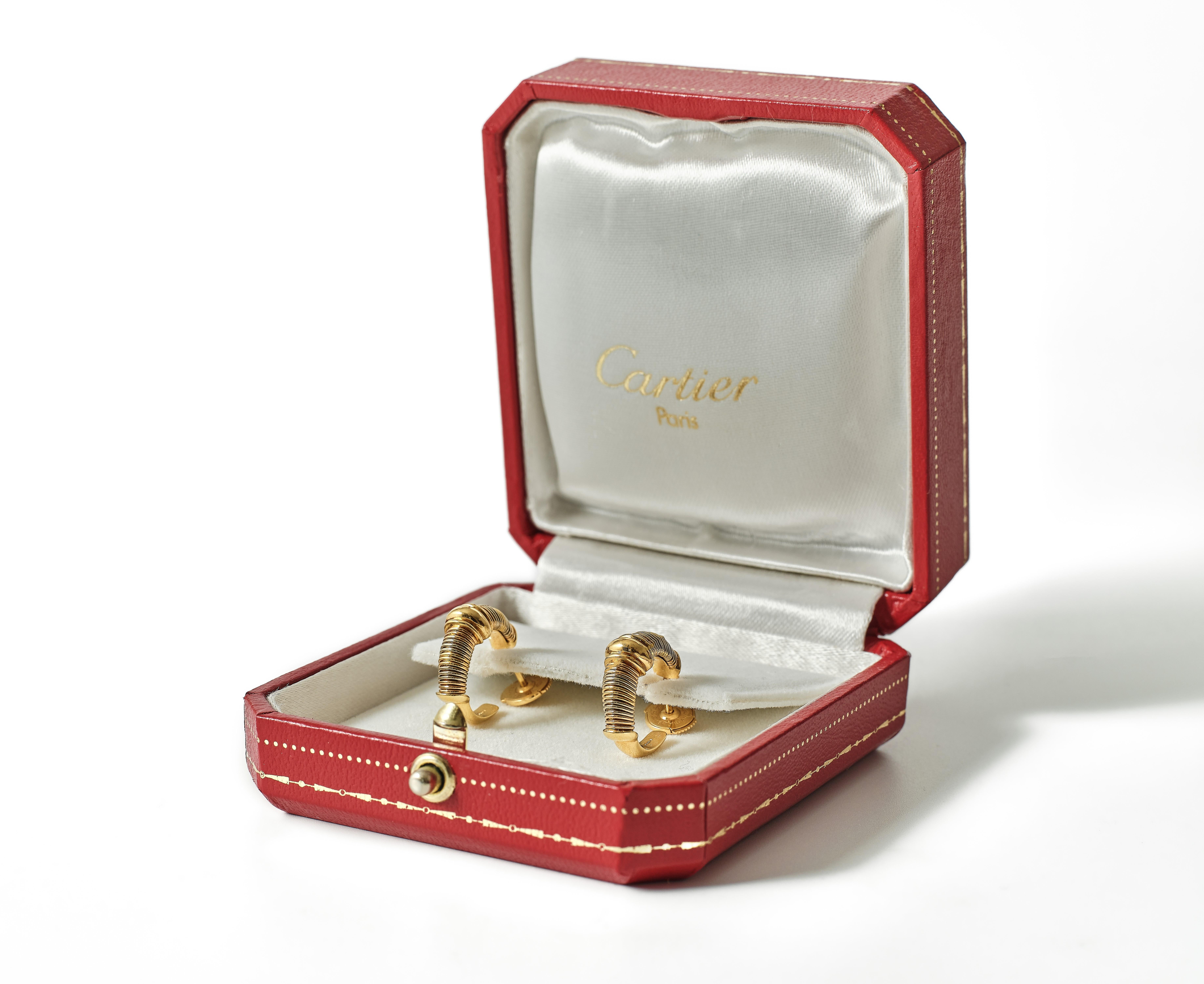 A matching pair, each consisting of gold wire alternating white, rose and yellow gold with a raised ribbed central terminal in yellow gold, fitted to the reverse with a secure post.. 

Accompanied by original Cartier certificate and box.

4.3-6.9mm