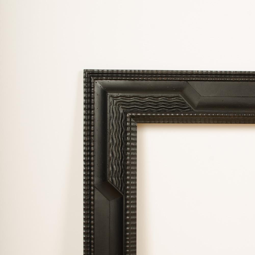 A pair of  Dutch style ebonized frame or mirror with blackened carved wood frame, nineteenth century. 