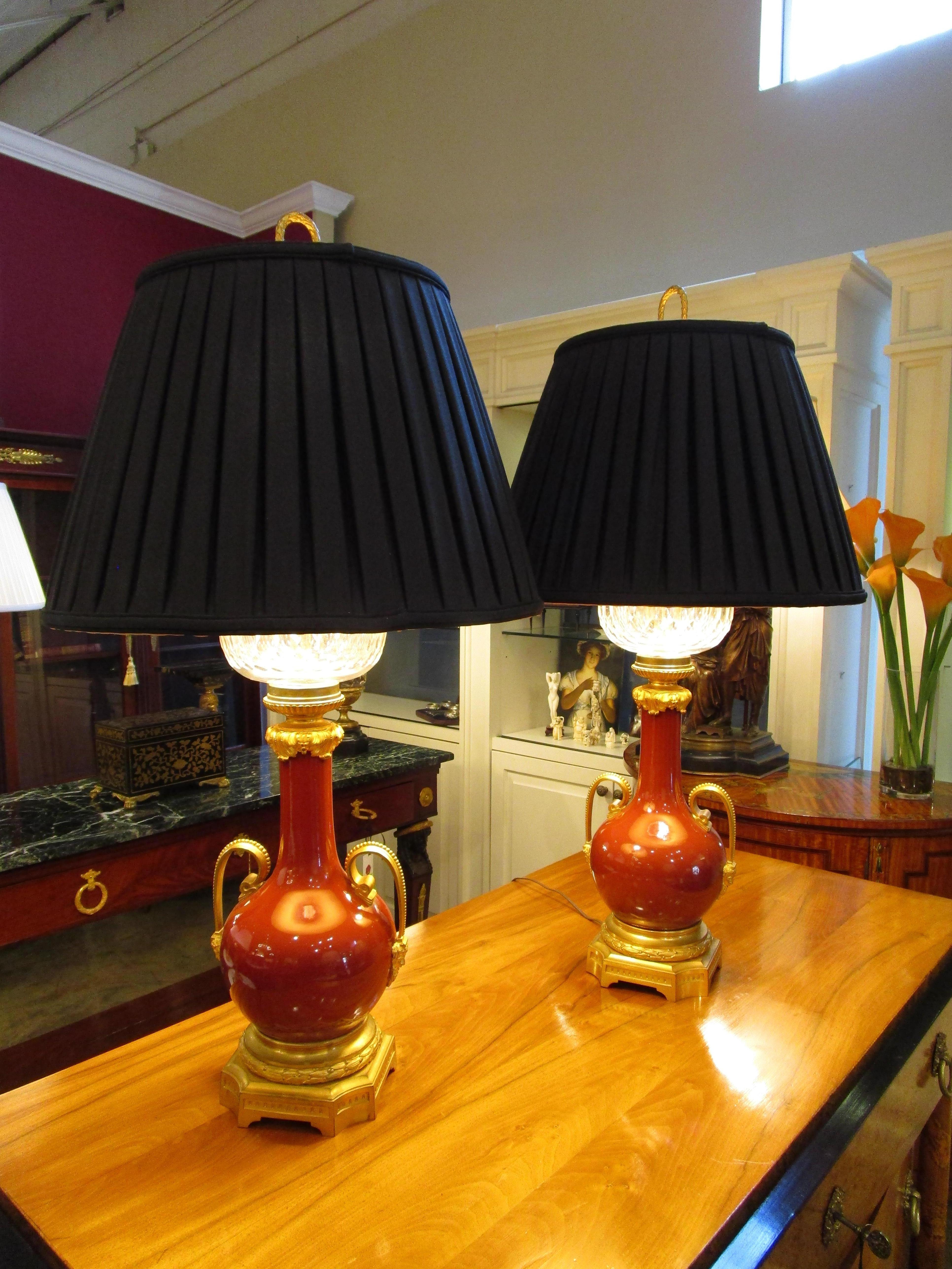 Gilt A pair of 19th c French sang de boeuf porcelain and gilt lamps with crystal tops For Sale