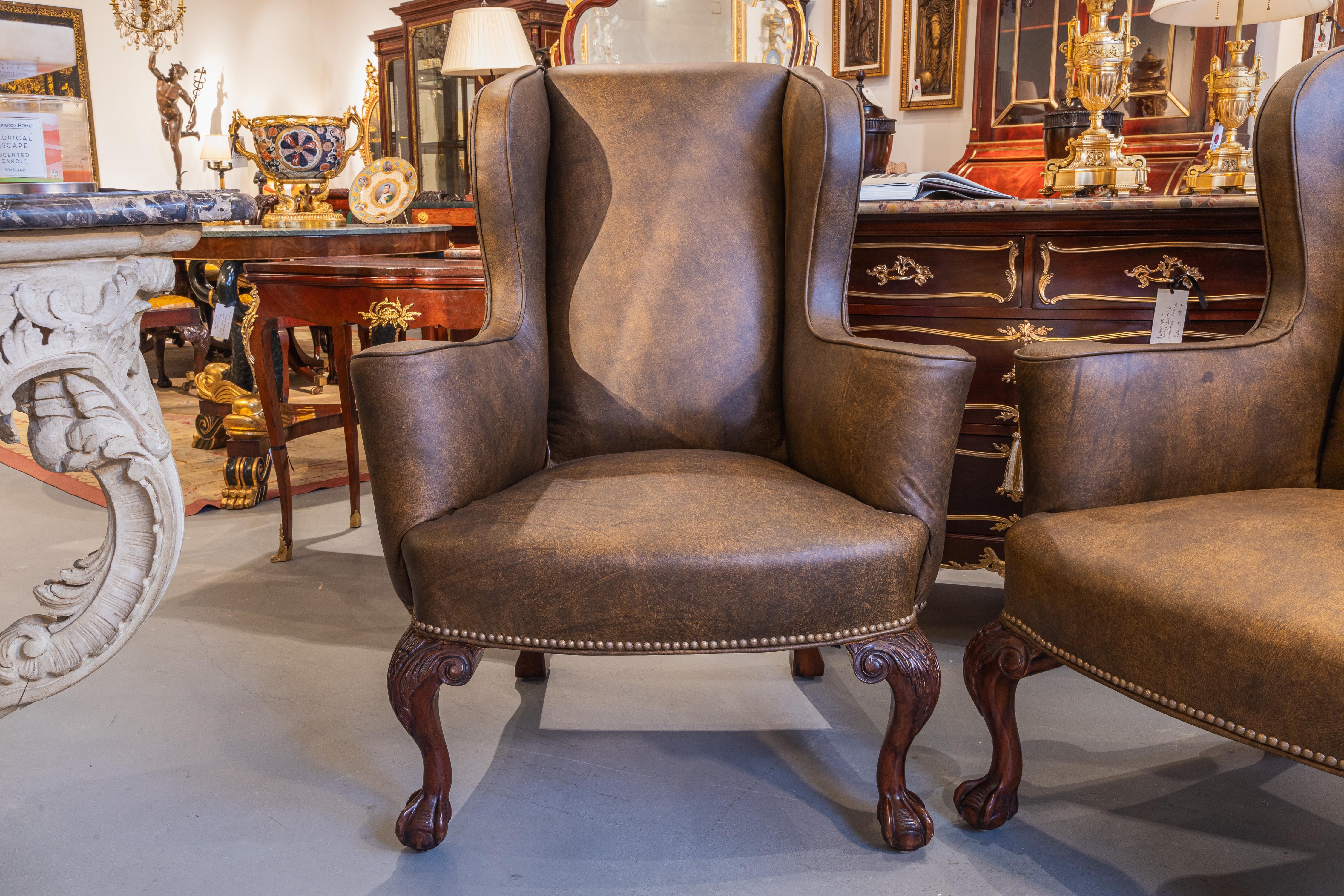 A very fine pair of 19th century George 1st style mahogany hand carved wingchairs. Chippendale ball and claw design. . Covered in a glazed English leather .