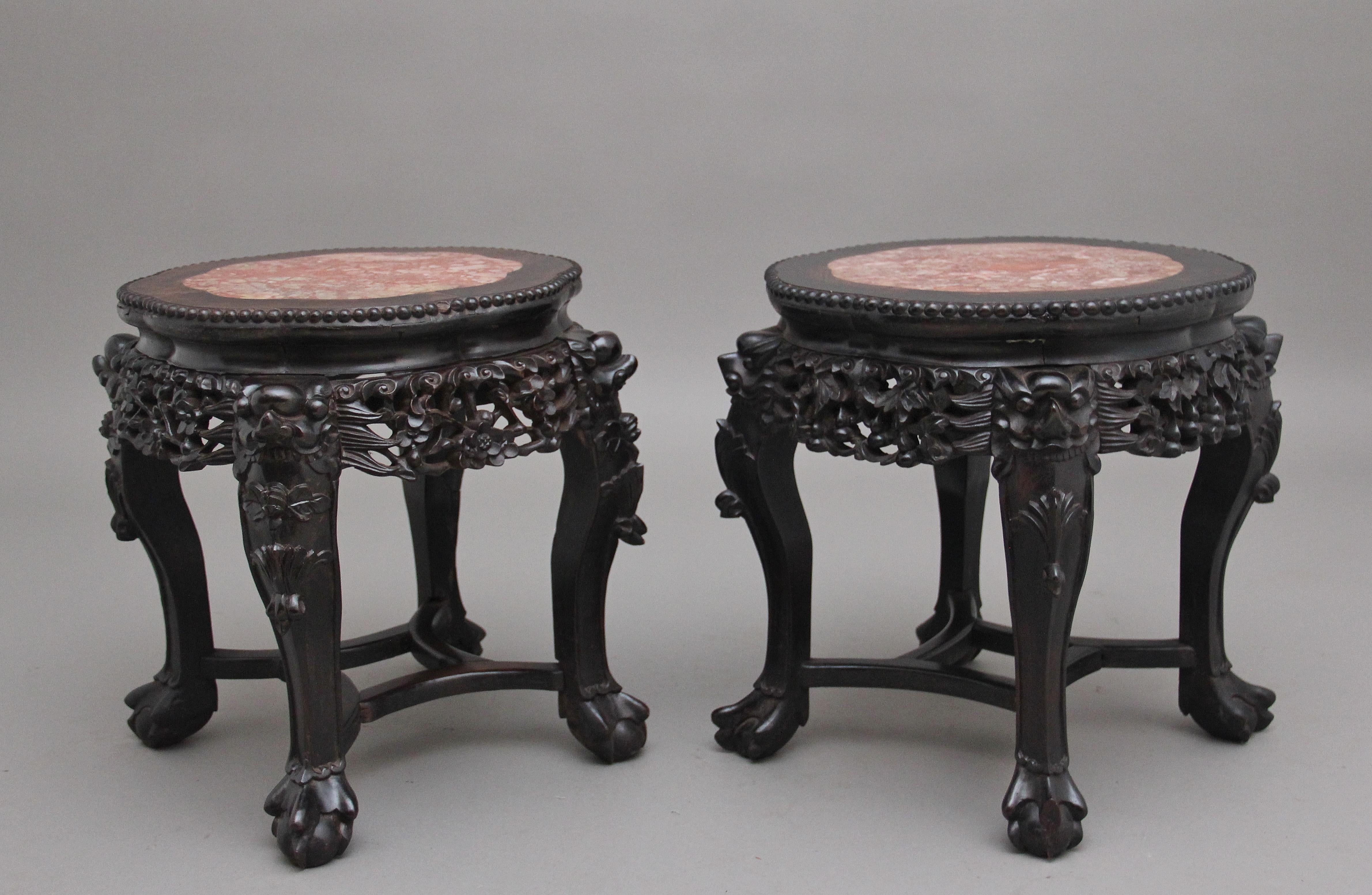 A pair of 19th century Chinese carved hardwood occasional table, the circular shaped top having a carved beaded edge with the original rose marble inserts with concave sides over a caved decorative apron on all sides, raised on shaped legs with