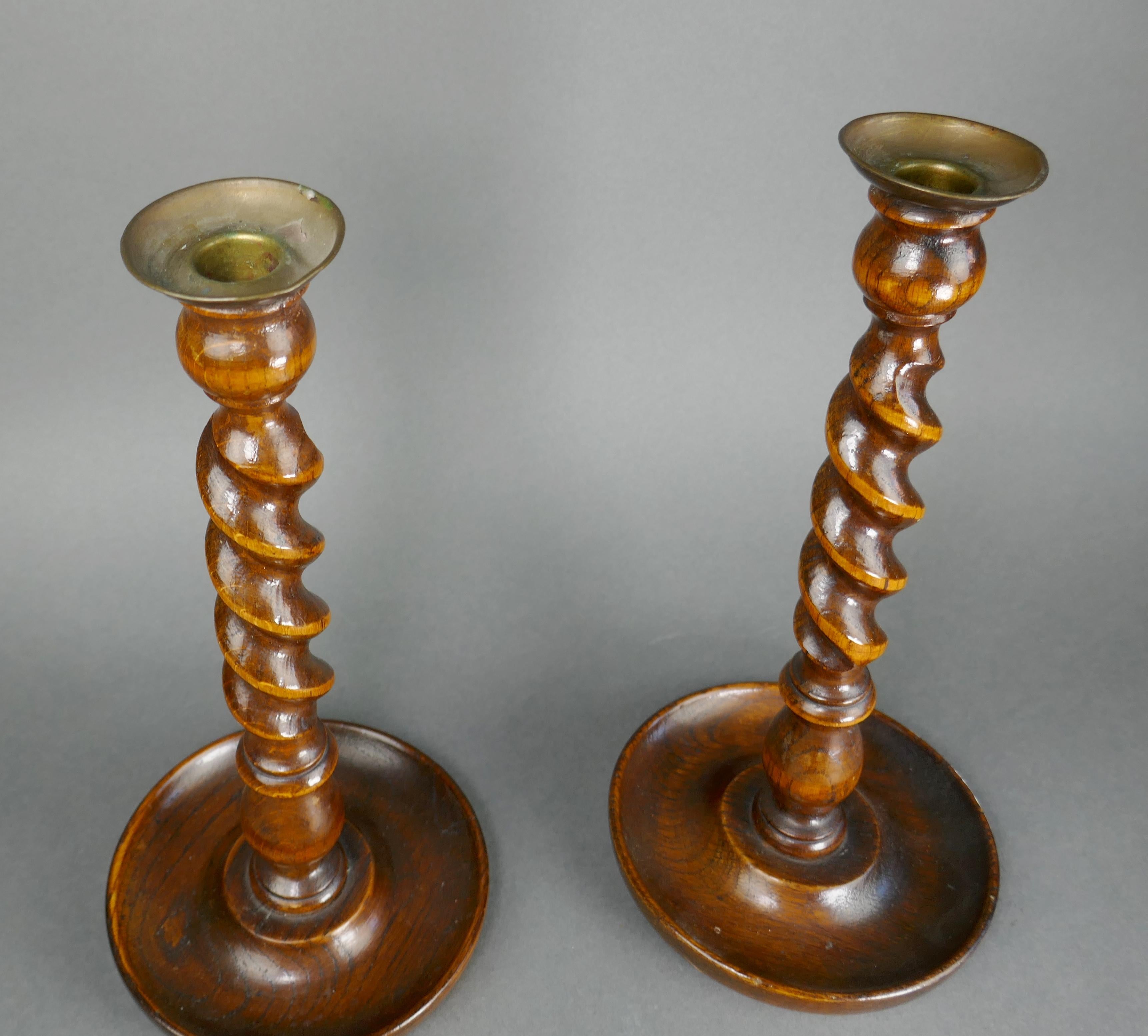 Antique barley twist turned oak candlesticks with brass inserts. Brass rim's are slightly out of round. 