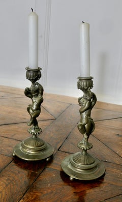 A Pair of 19th Century Brass Candle Sticks with Dancing Cherubs
