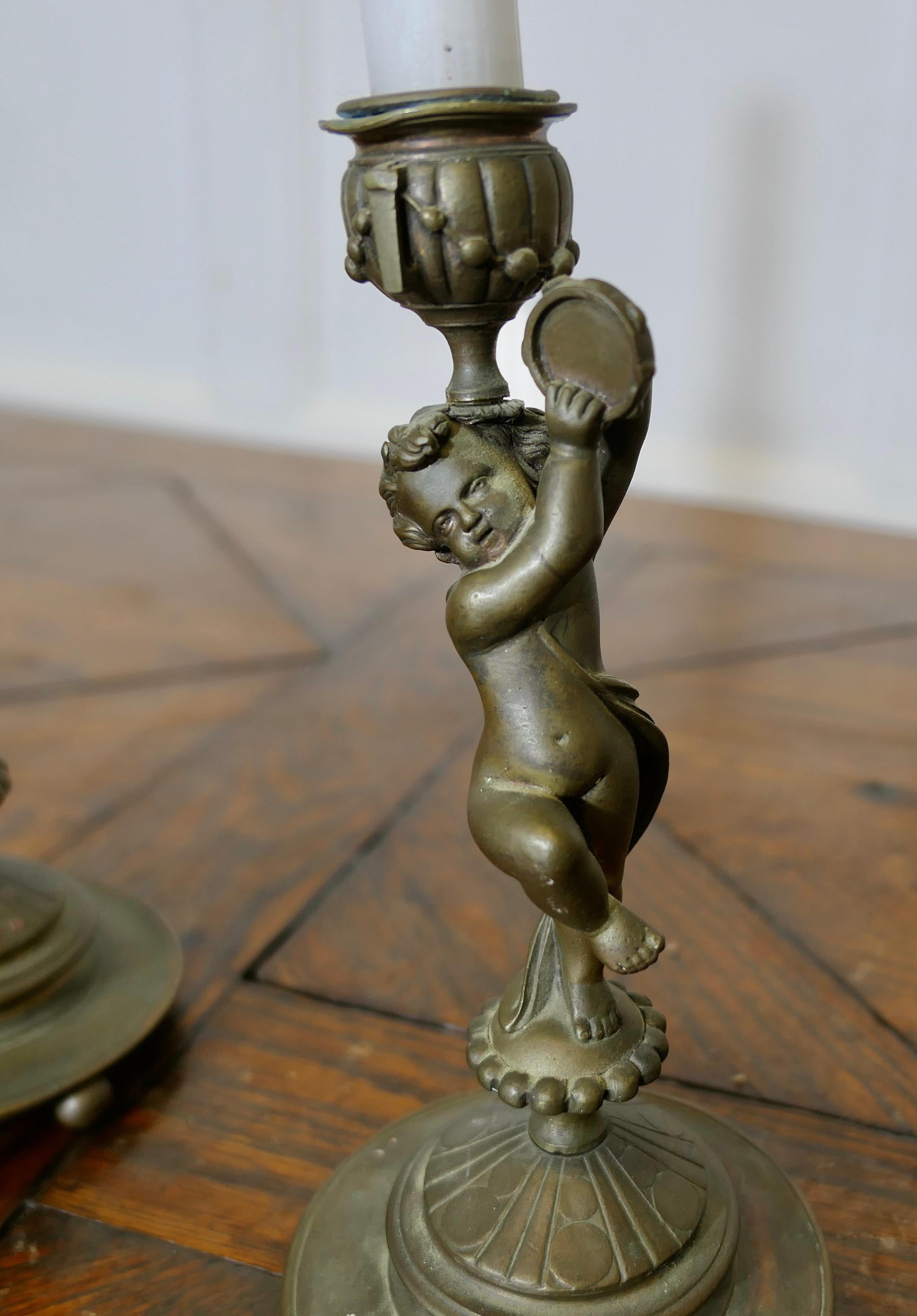 French Provincial A Pair of 19th Century Brass Candle Sticks with Dancing Cherubs For Sale