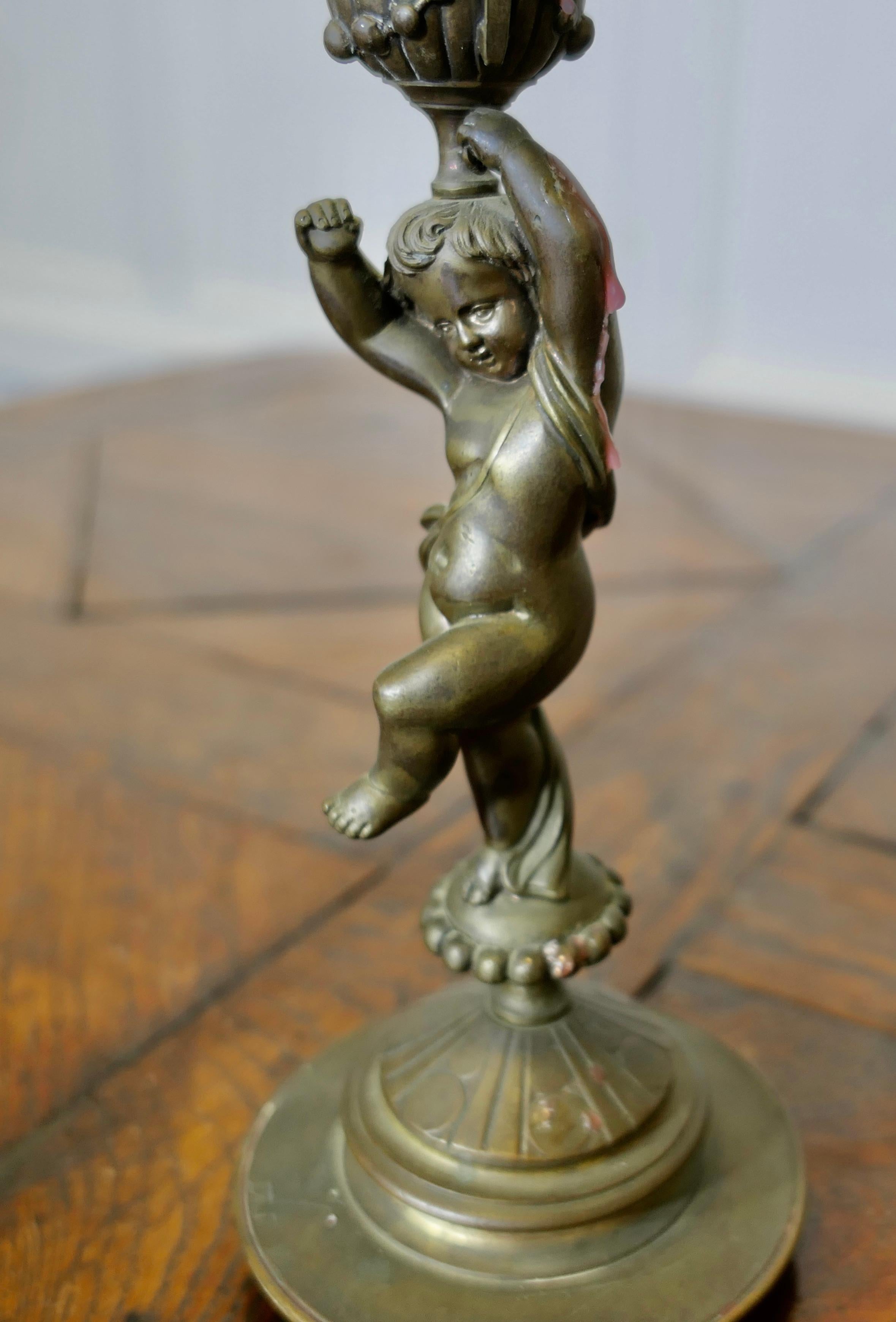 A Pair of 19th Century Brass Candle Sticks with Dancing Cherubs In Good Condition For Sale In Godshill, Isle of Wight