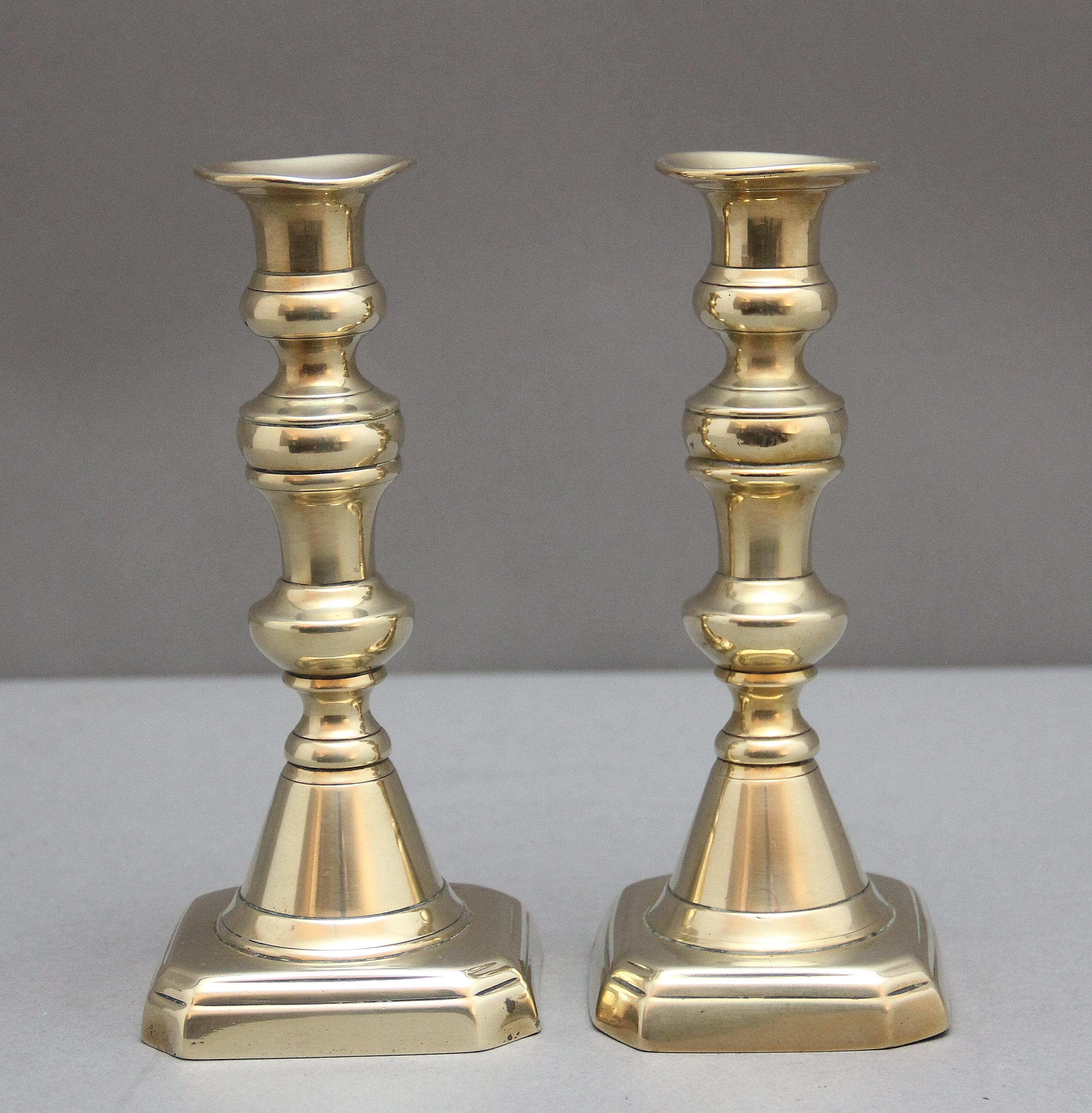 Coppia di candelieri in ottone del XIX secolo, con colonne tornite e sagomate sollevate su una base quadrata.  Circa 1860.