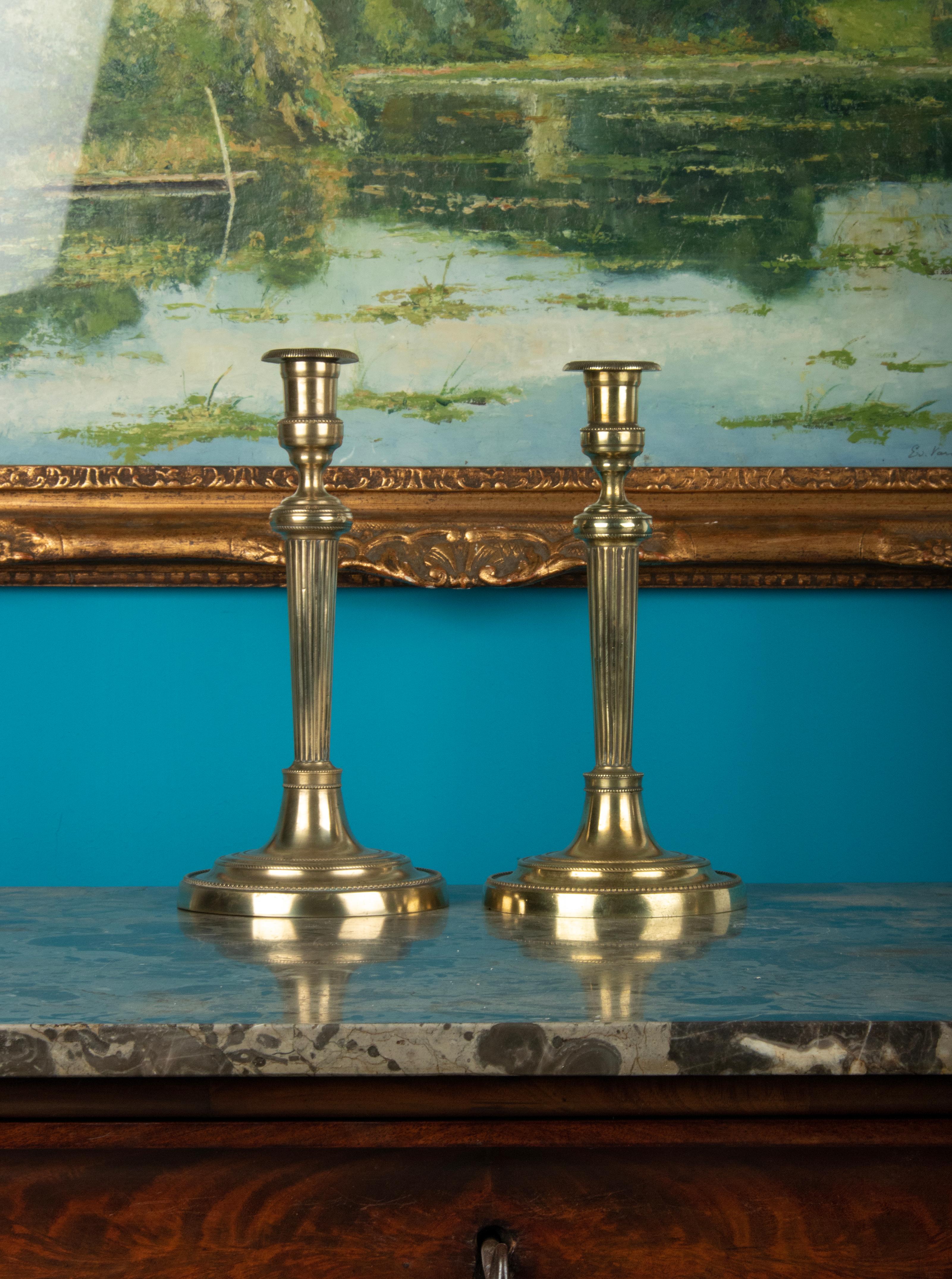 A pair of brass candlesticks. Beautifully decorated with pearl edges and fluted stem. Louis XVI style. The candlesticks date from around 1880-1890, originating from France.
