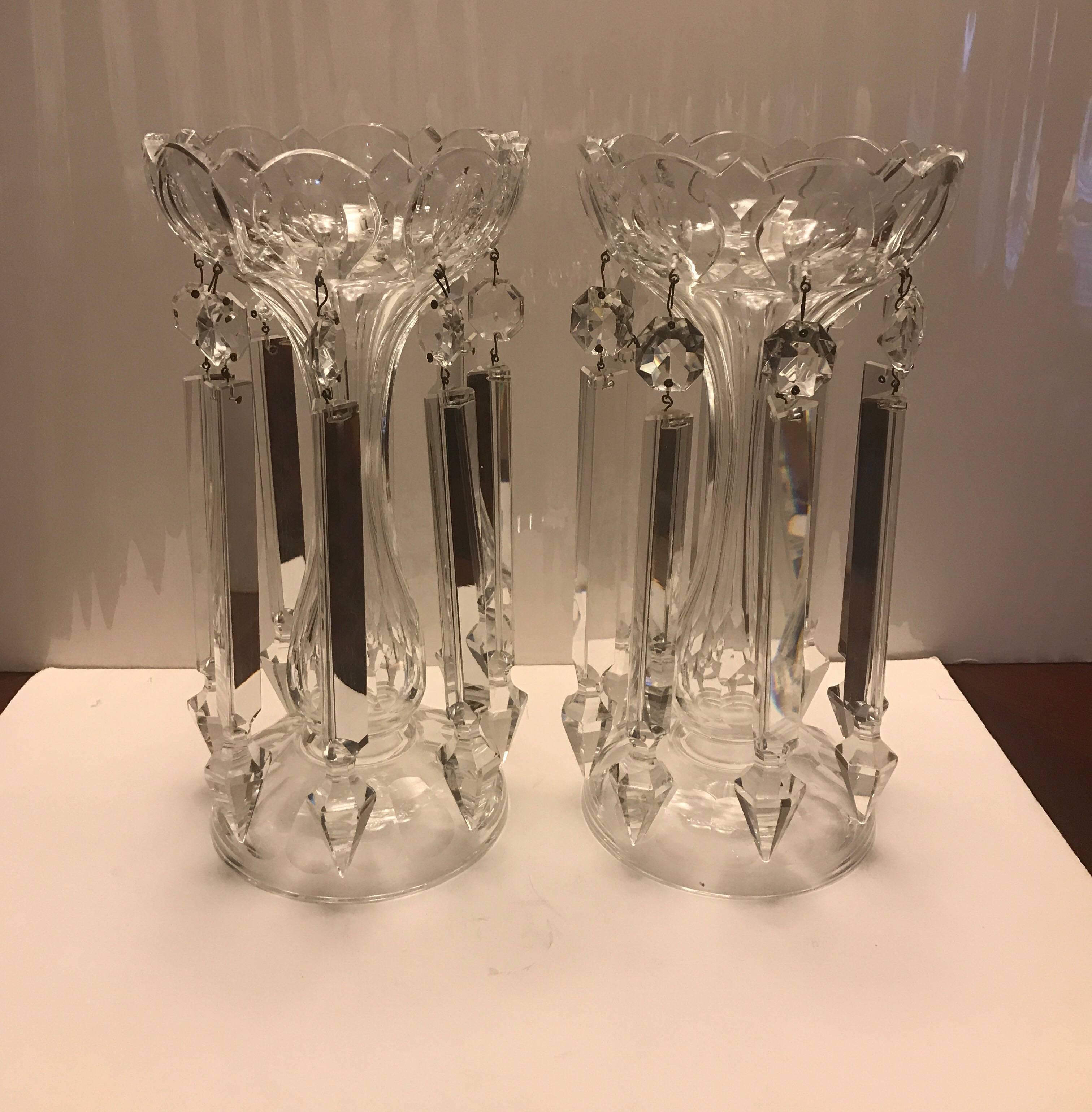 A pair of elegant cut-glass mantel lusters. The bowl tops with tapered panel cut centers with round bases. The candle holders have shimmering mirror like long cut speared prisms all around.  Hand blown, hand cut on a wheel 