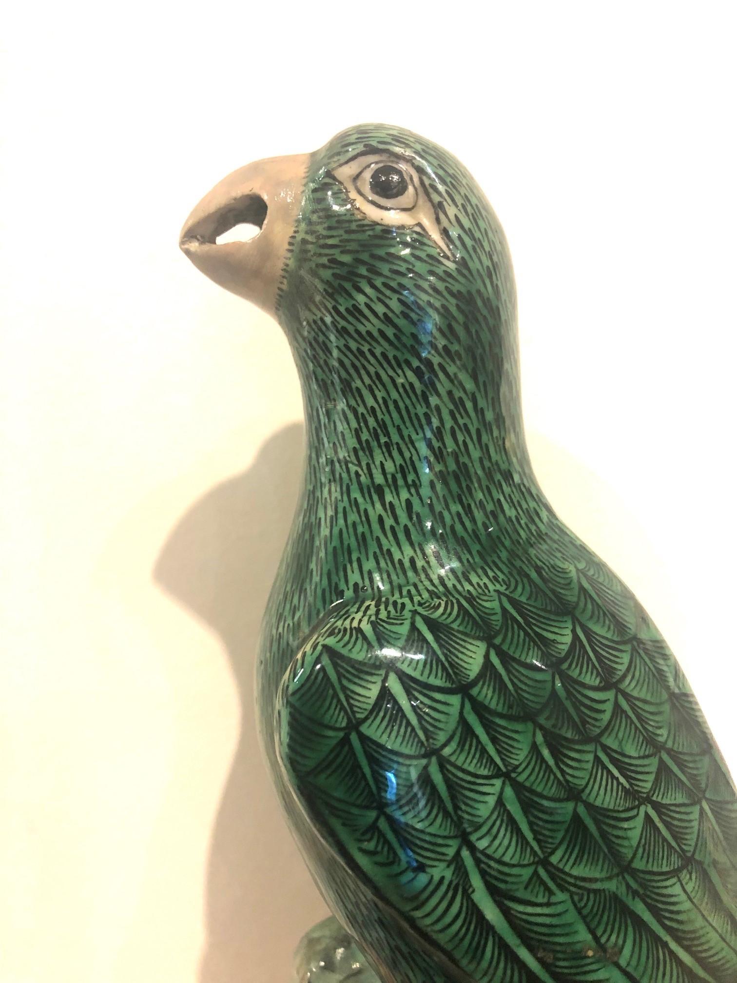 The birds facing inwards, each glazed green with Fine black linear designs portraying the feathers terminating in grey beak and feet, perched upon a ridged and pierced base in conforming colors.

Published Sotheby's Melbourne 2010.
