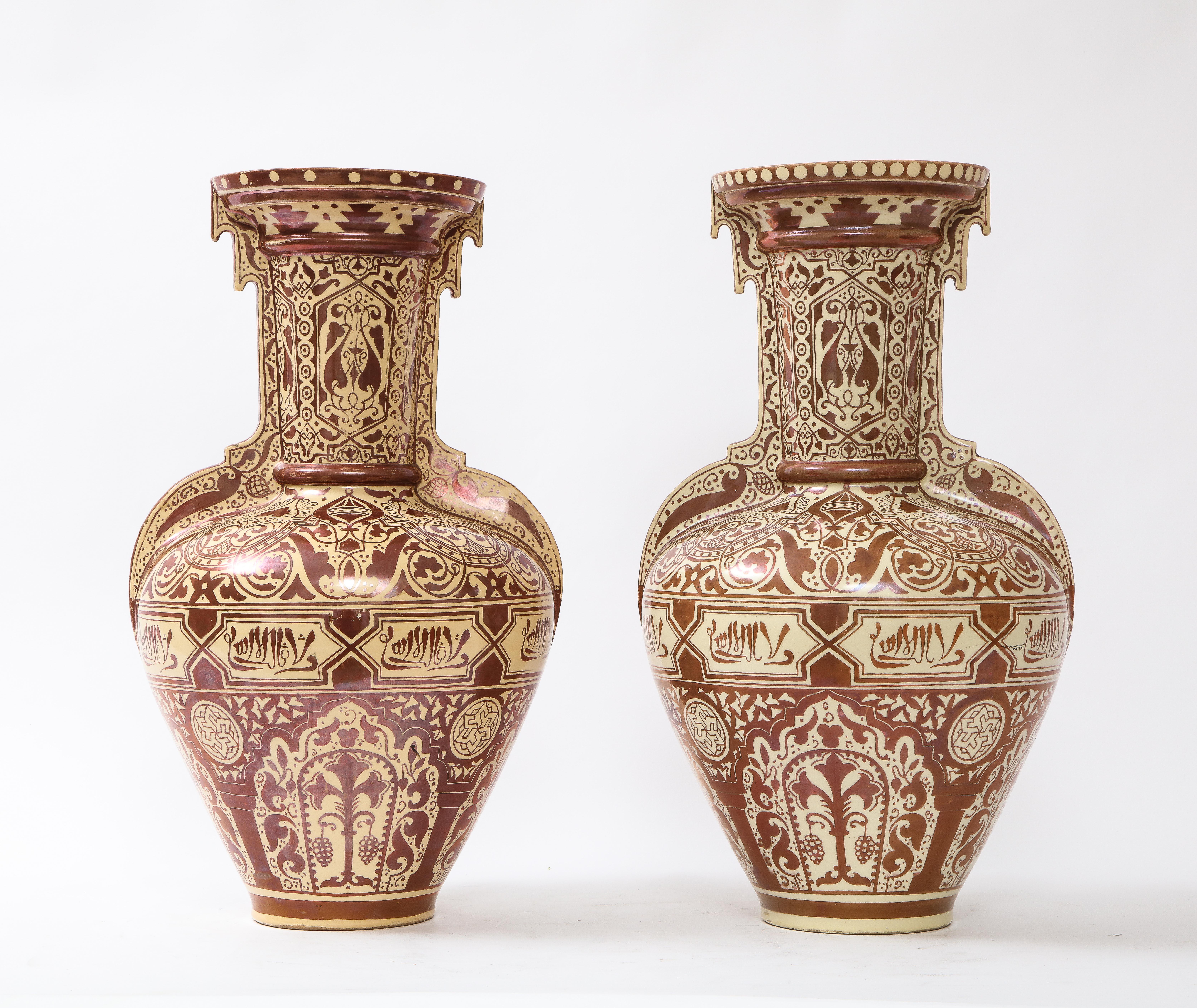 A fantastic pair of 19th century Continental Porcelain Orientalist/Moorish Alhambra form vases. Each is beautifully decorated with a cream and burgundy ground in an Orientalist/Moorish motif. The vases have hand-painted designs of flowers, vines,
