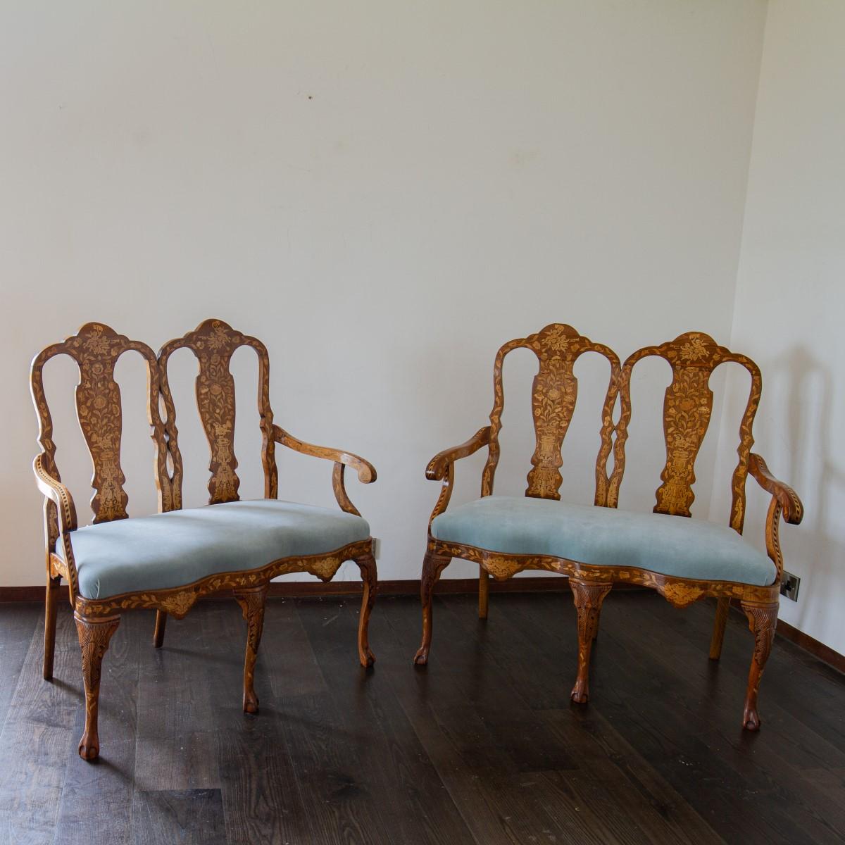 A pair of Dutch, 19th century walnut double chair back, two seater sofas, upholstered in a sky blue velvet with satinwood marquetry inlays of flora, cherubs, birds and masks. The serpentine seat rail is supported by cabriole legs complete with