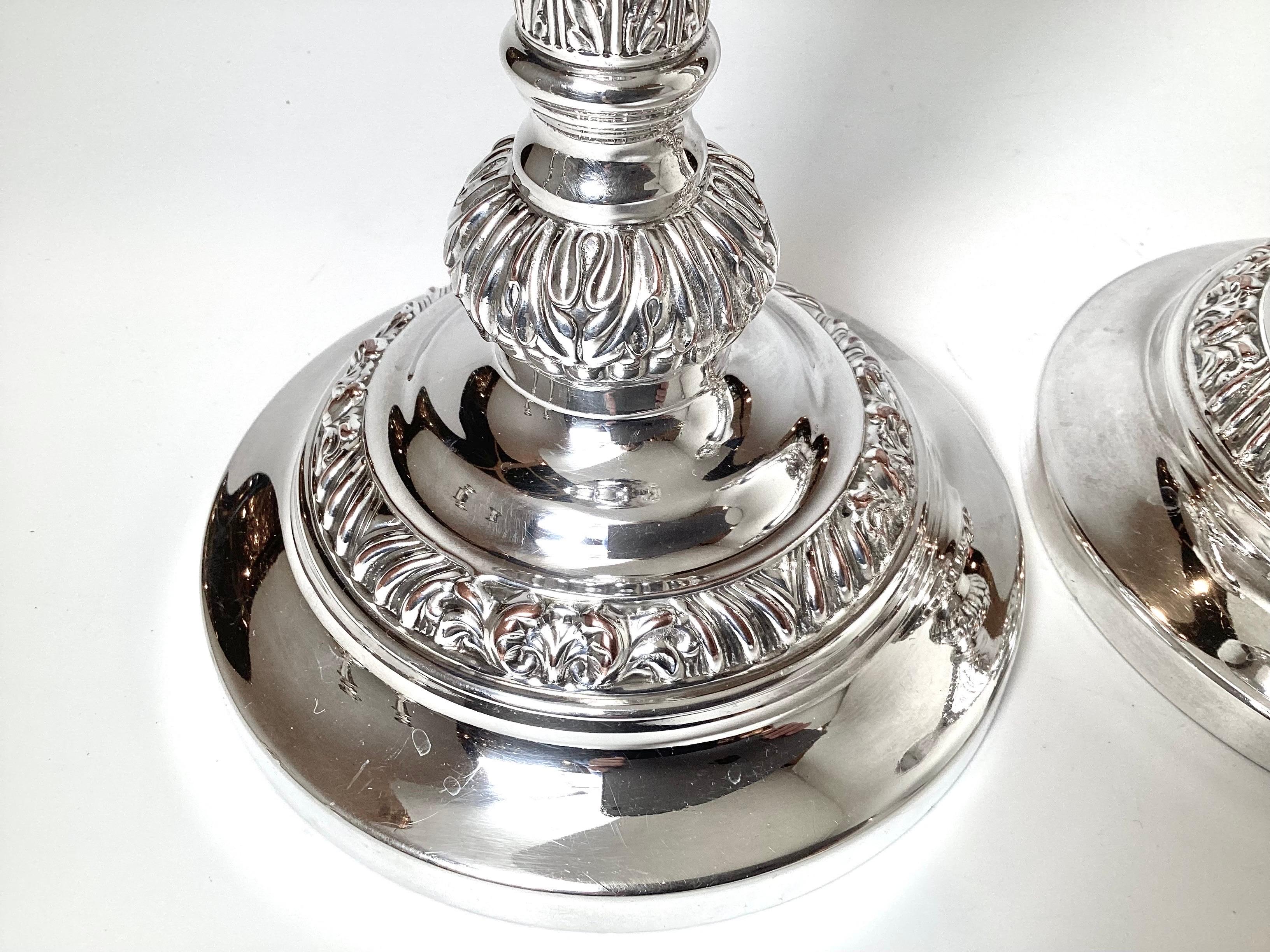 A handsome pair of larger English silver plate candlesticks with chase decoration. The height is 12.75 and 6.25 inches wide. There is some minor copper bleed on the high spots.