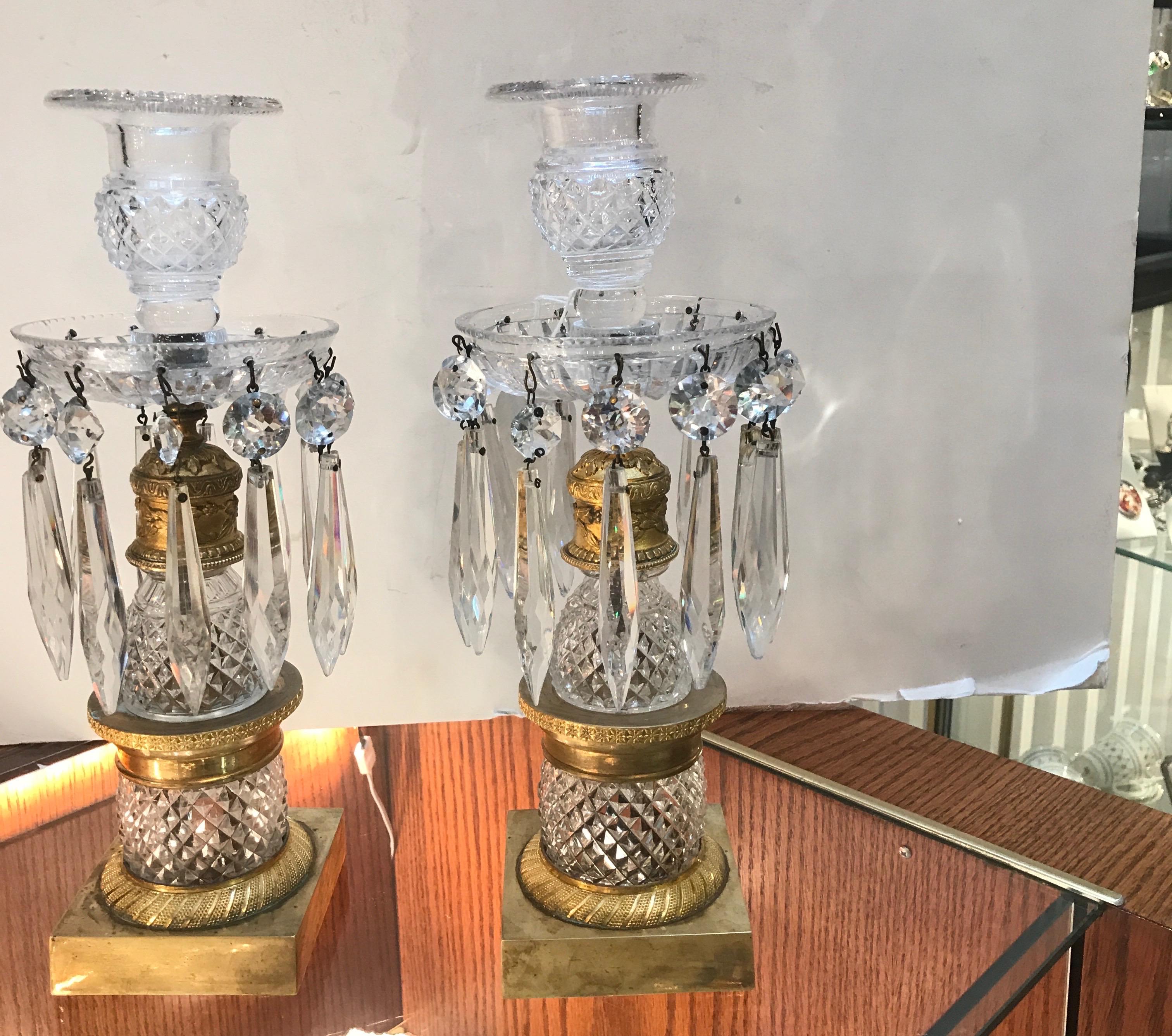 Elegant pair of French mid-19th century cut glass and gilt bronze luster candlesticks. The cut glass is attributed to Baccarat with cast and gilt bronze mounts and square base. 11.5 inches tall, 4.5 inches in diameter, the bases are 3.25 inches