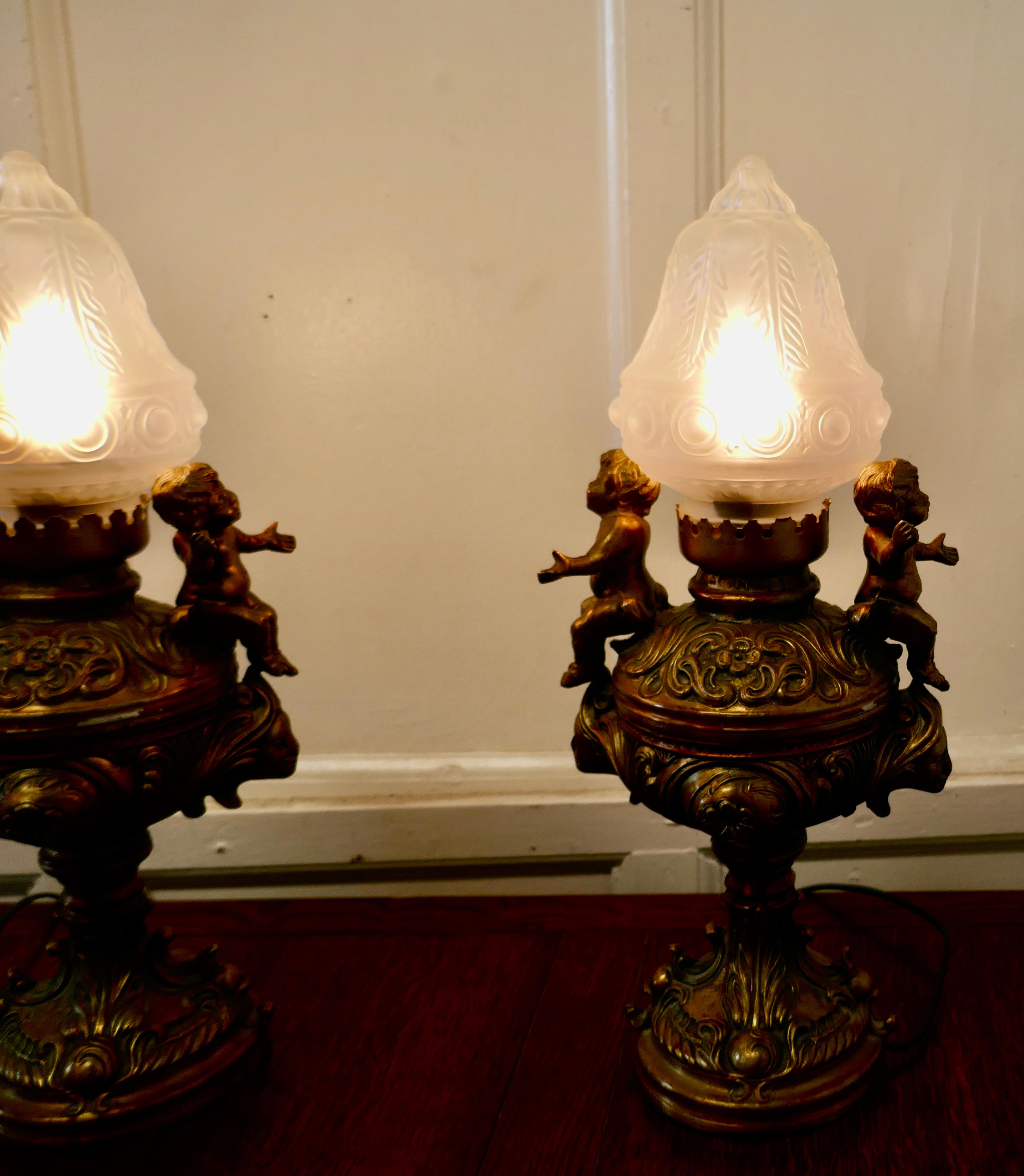 A Pair of 19th Century gilt lamps in the form of Cherubs or Putti 

This charming pair are made in spelter which has a gilt finish, they come with beautiful decorative glass shades
The lamps are in sound condition the wiring is fairly new

The