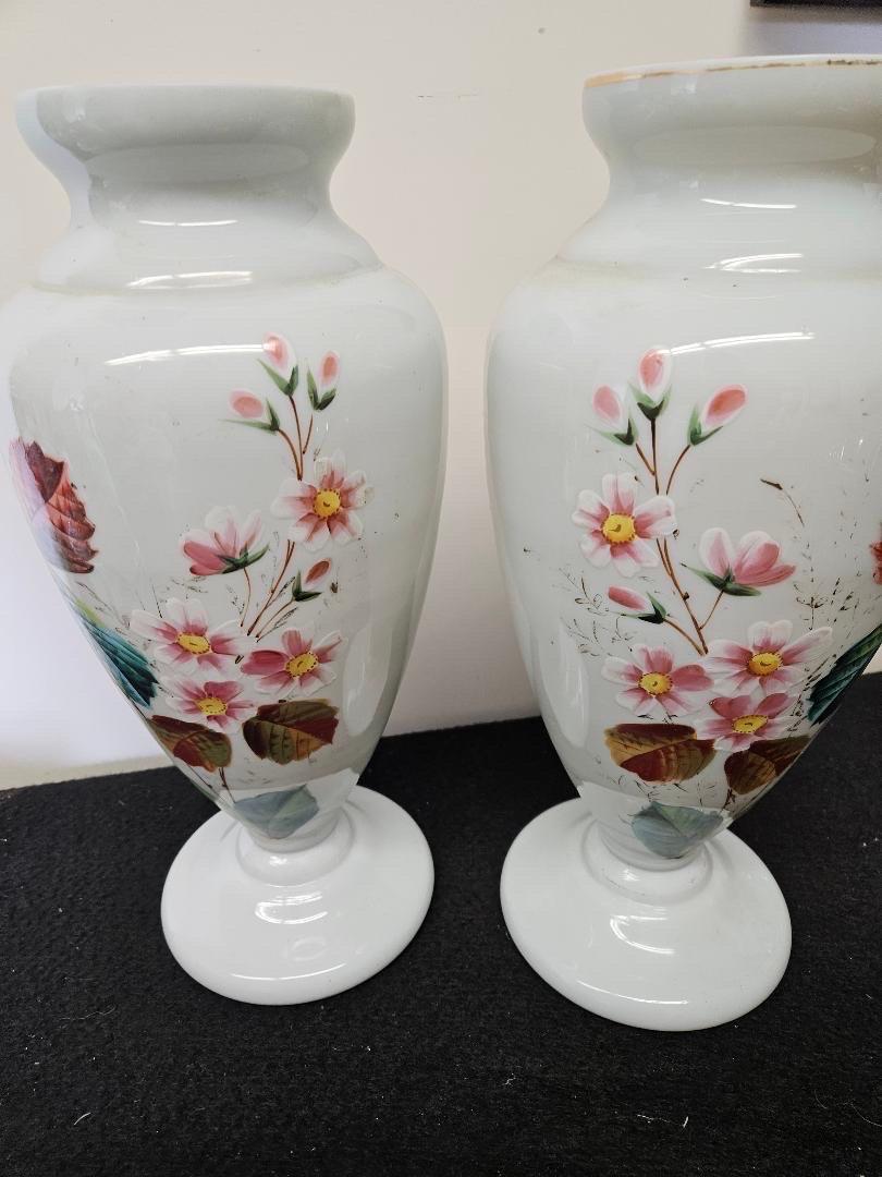 A pair of hand blown and hand painted white opaline vases, France, Circa 1870' The vases, 15 inches tall with floral and leaf decoration with round pedestal bases.  