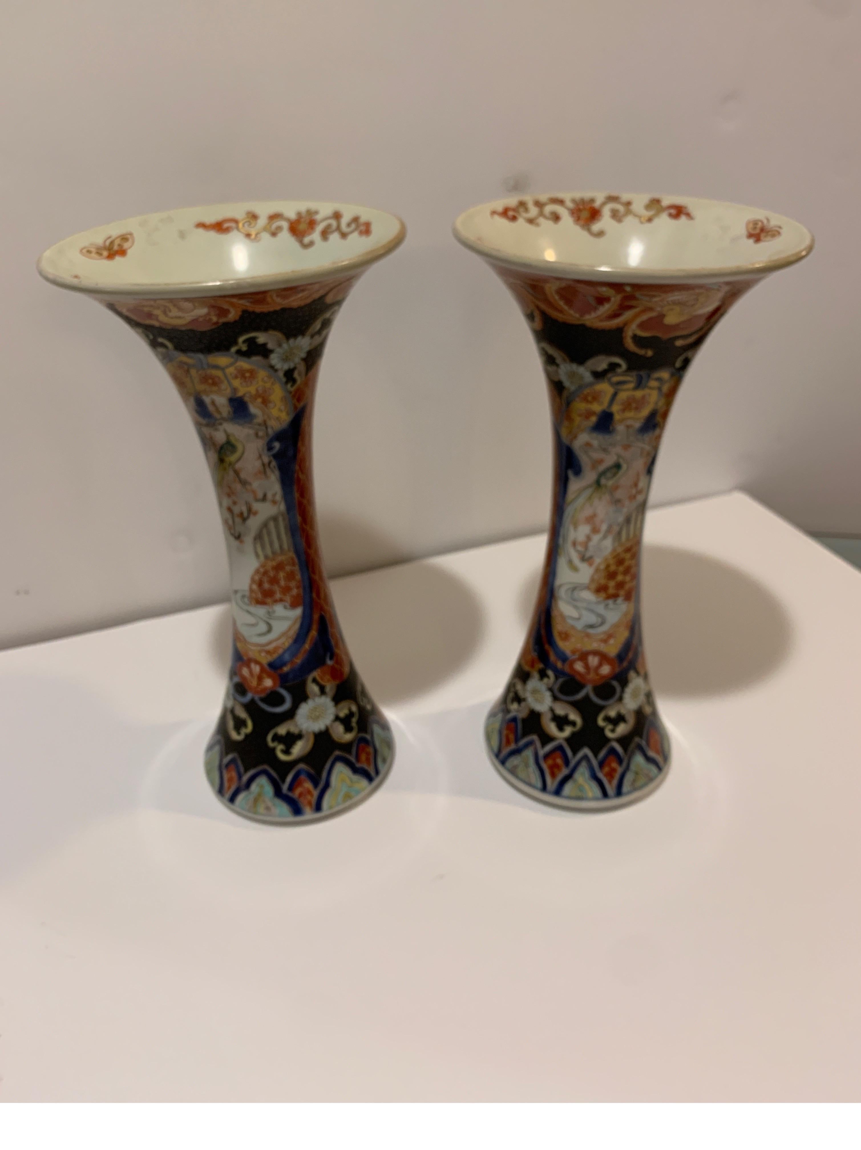 Excellent pair of hand painted Japanese Imari porcelain trumpet vases in Classic Imari iron red and blue. Rare form and an original matched pair, circa 1880, 12 inches tall.