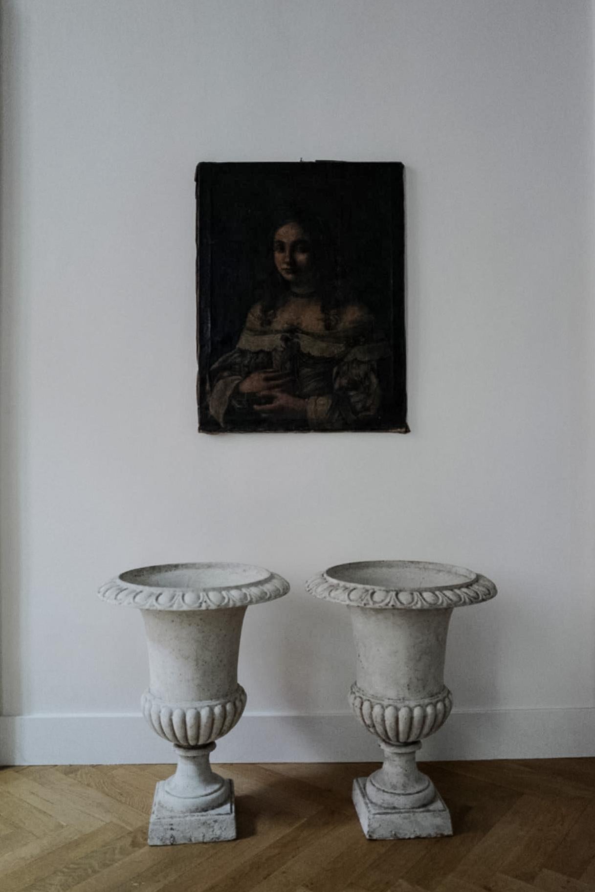 A pair of large neoclassical 19th century iron garden urns painted white.