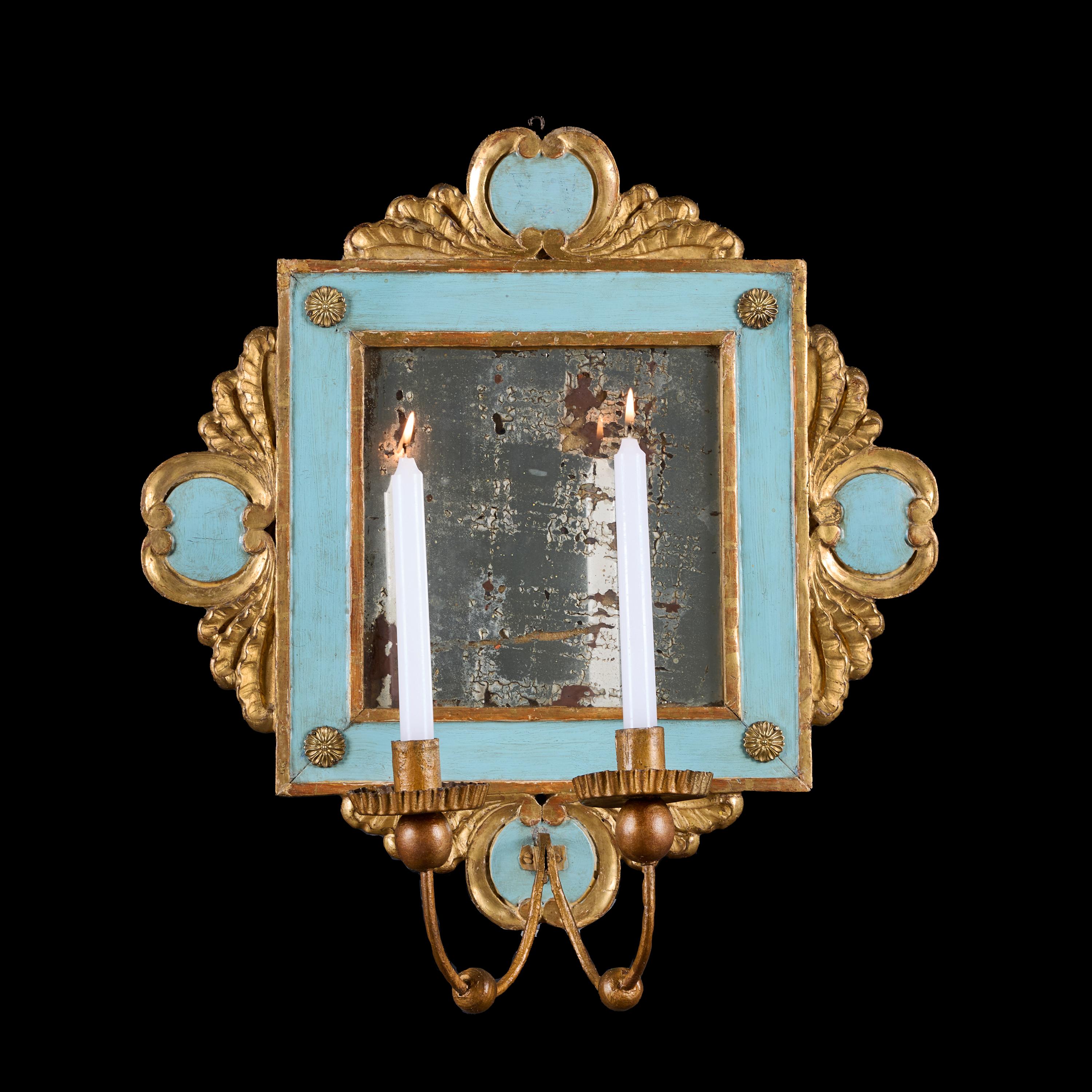 Italia, circa 1850

Coppia di appliques a girandola piemontesi della metà dell'Ottocento con bracci a candela gemelli e gocciolatoi in tole dorate, le piastre quadrate a specchio al mercurio montate all'interno di cornici dipinte di blu e in legno